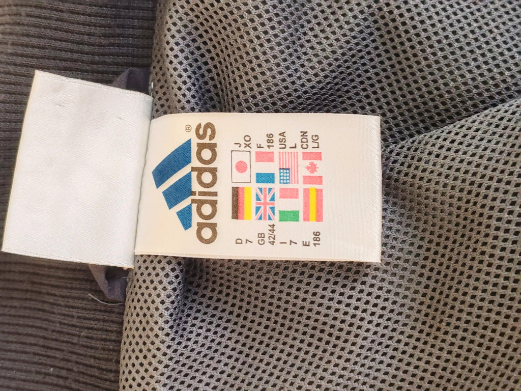 Adidas grey track jacket, high collar, zip closure, tonal details, vintage 90s style.