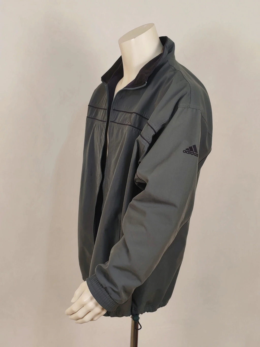 Adidas grey track jacket, high collar, zip closure, tonal details, vintage 90s style.