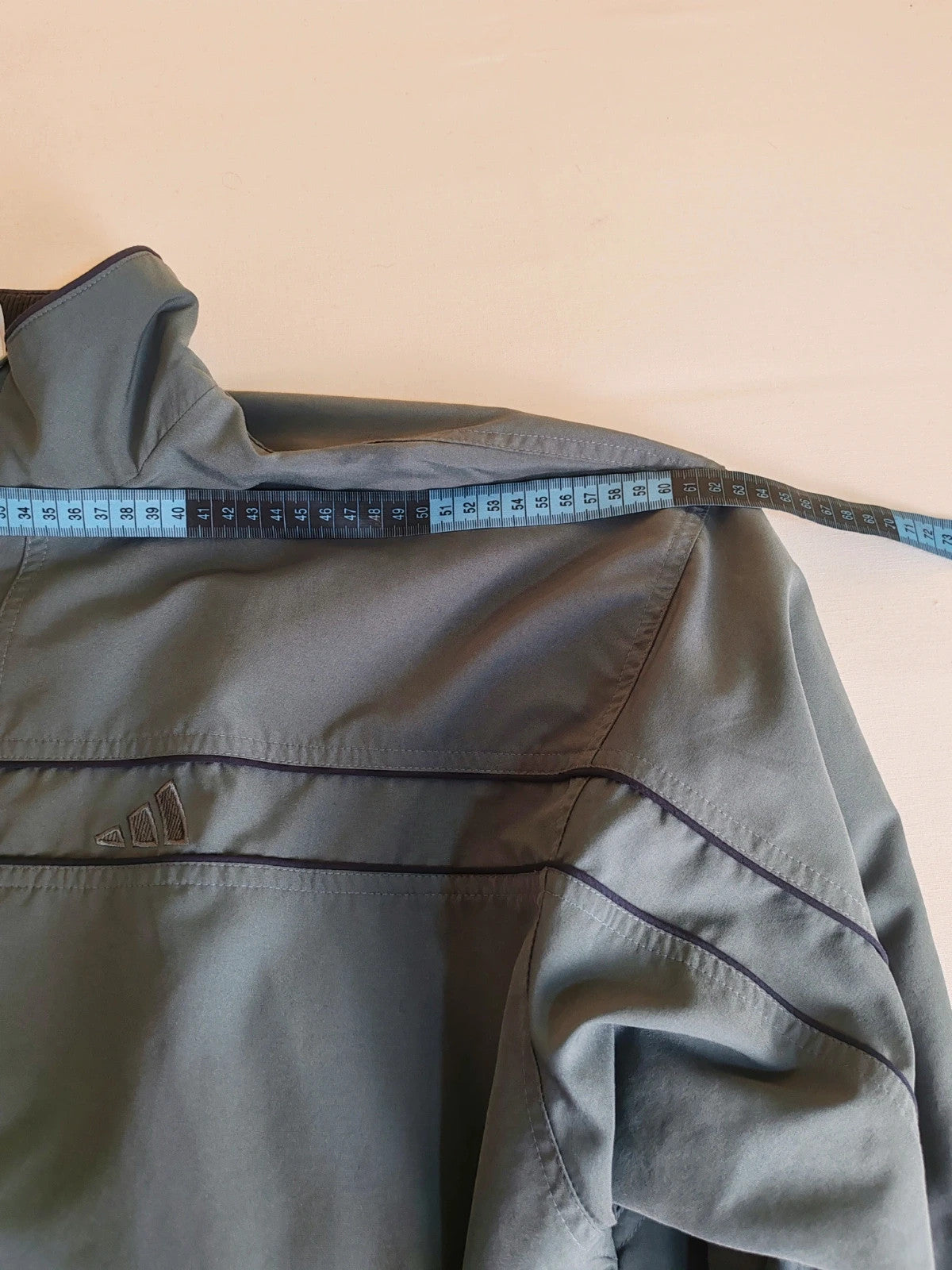 Adidas grey track jacket, high collar, zip closure, tonal details, vintage 90s style.