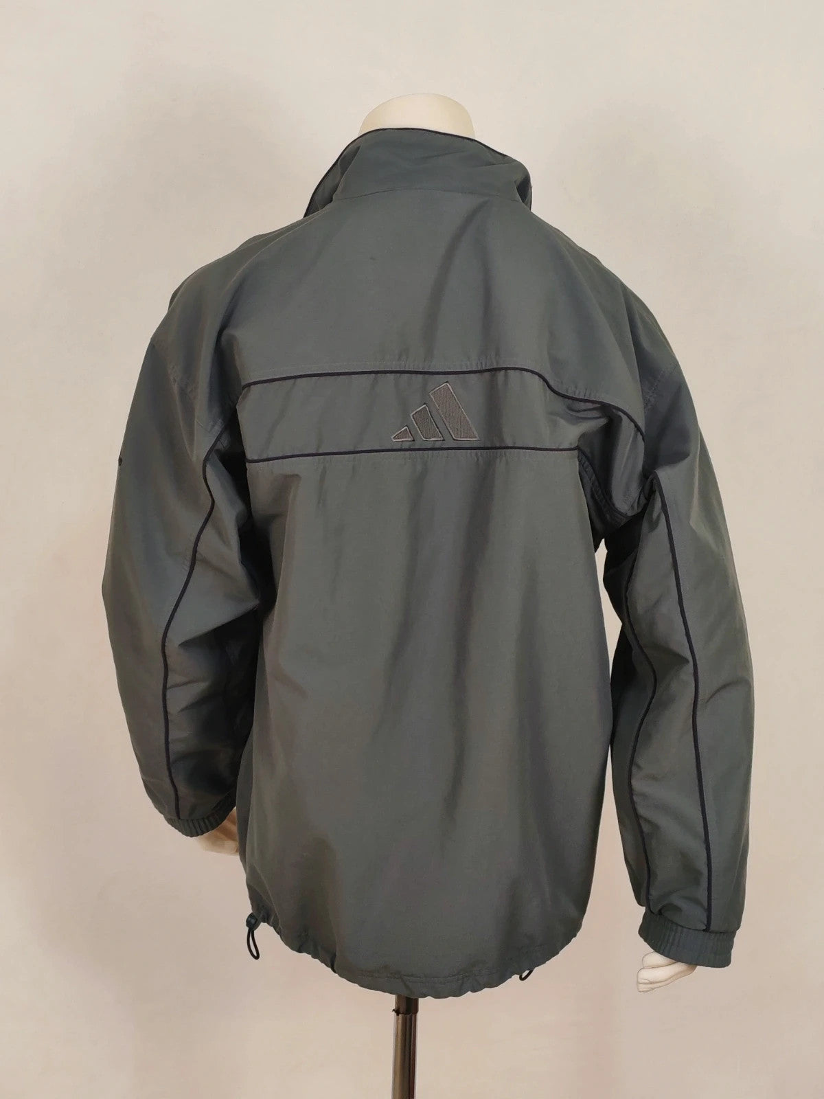 Adidas grey track jacket, high collar, zip closure, tonal details, vintage 90s style.