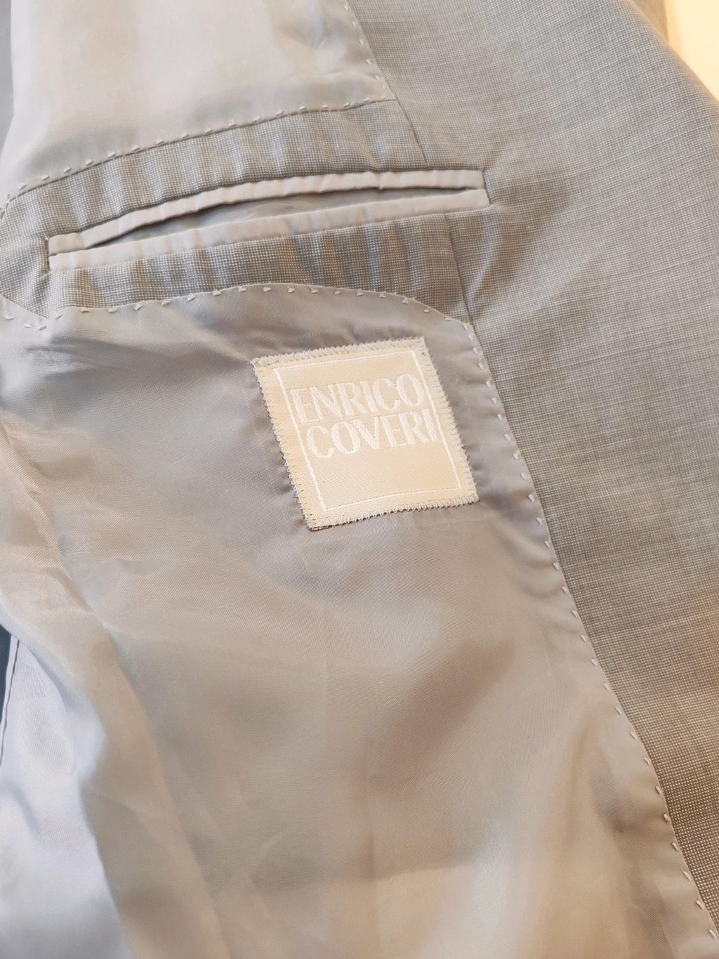 Enrico Coveri grey tailored suit with structured jacket, classic lapels, and micro-pattern.