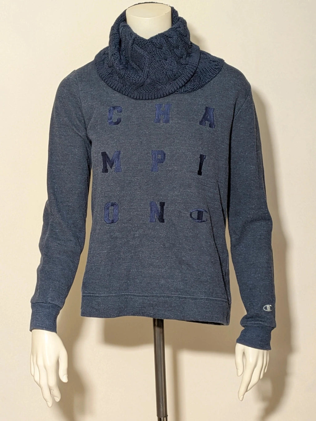 Champion navy turtleneck jumper with cable knit collar and embossed logo on front.