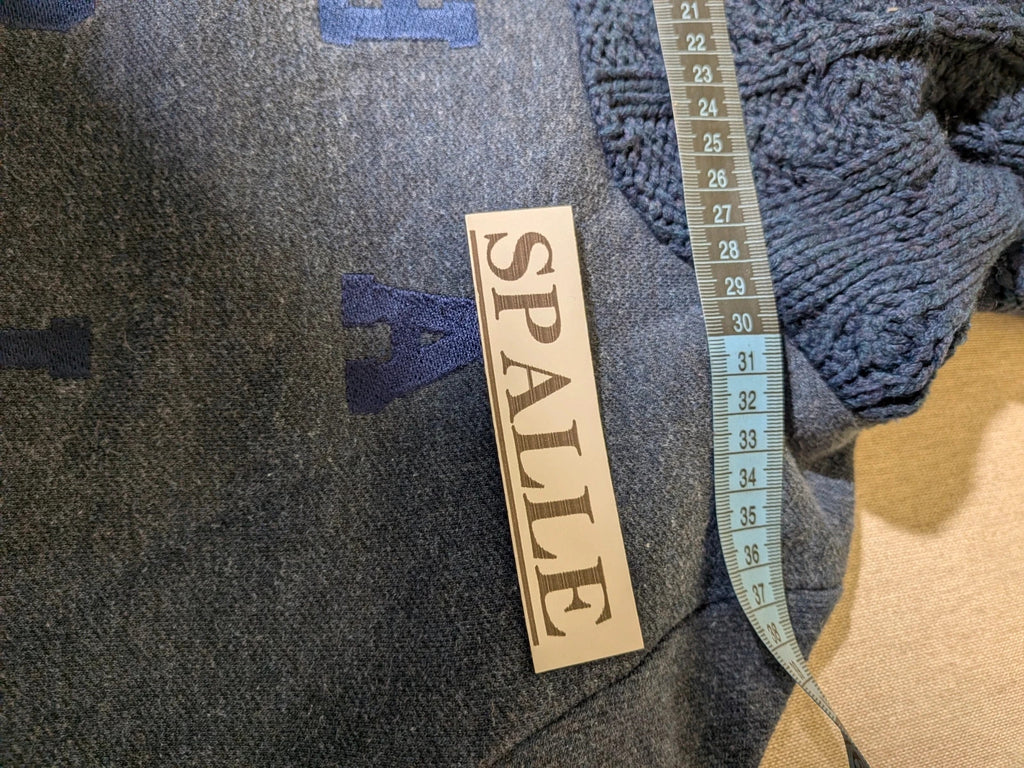 Champion navy turtleneck jumper with cable knit collar and embossed logo on front.