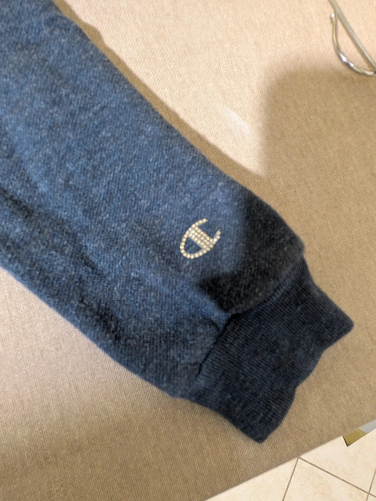 Champion navy turtleneck jumper with cable knit collar and embossed logo on front.