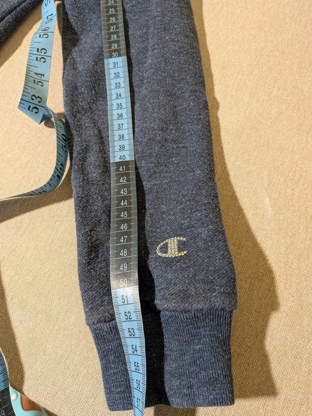 Champion navy turtleneck jumper with cable knit collar and embossed logo on front.