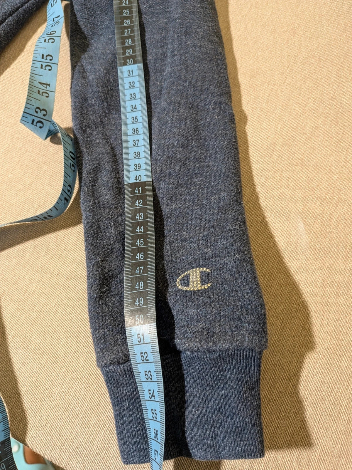 Champion navy turtleneck jumper with cable knit collar and embossed logo on front.