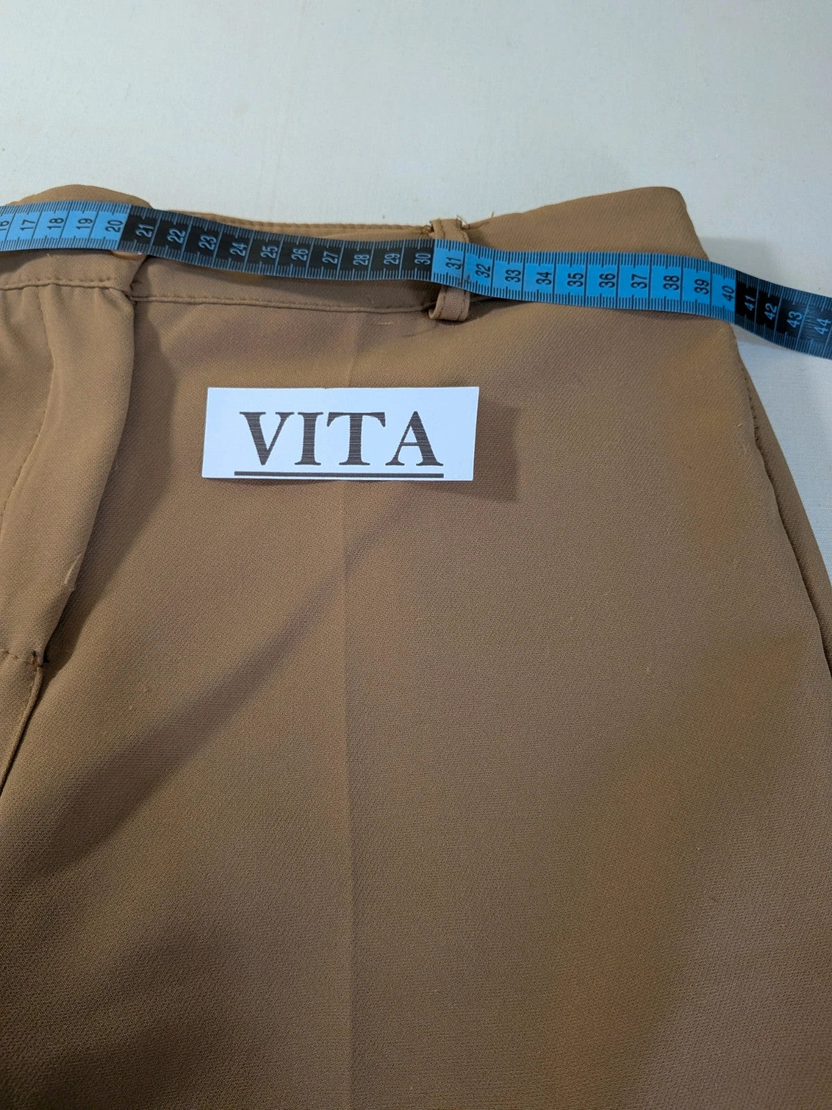 Zara Basic brown pants with flared cut, quilted jacket, gold zipper details.
