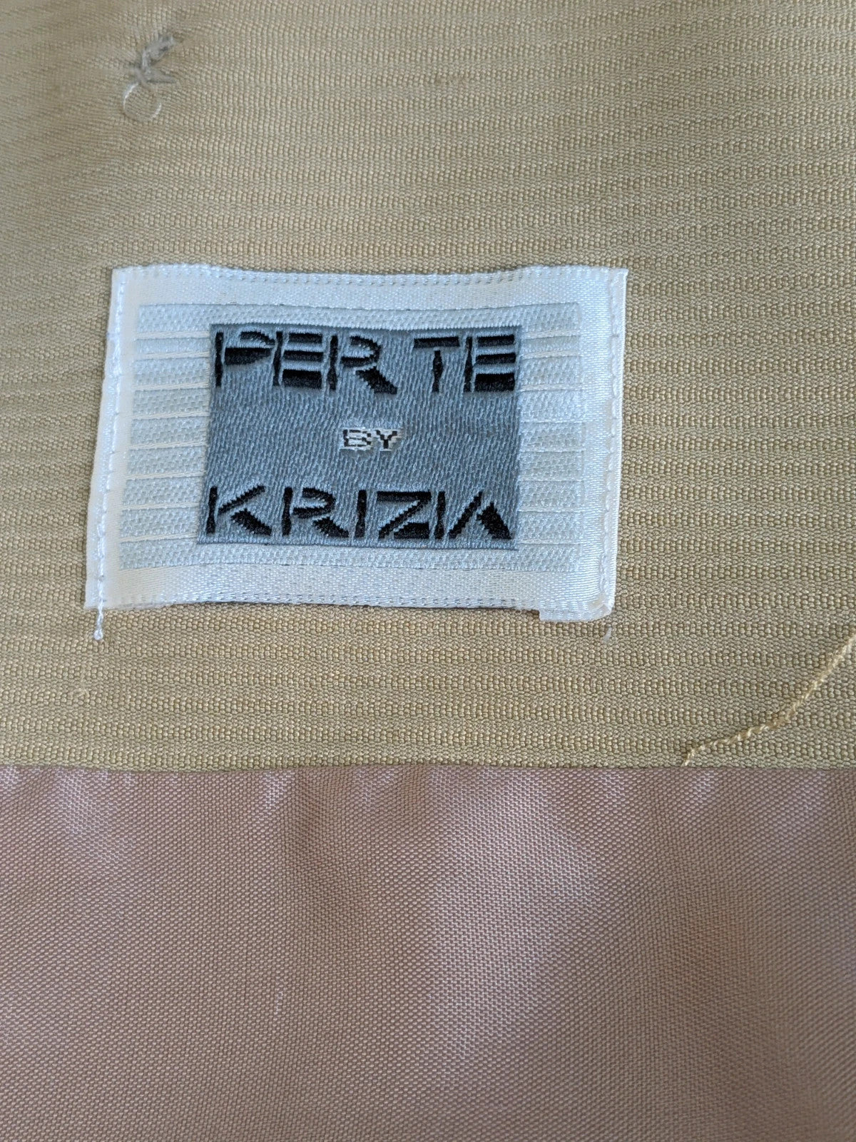 Krizia beige skirt suit with structured jacket, gold buttons, and pleated silk fabric.
