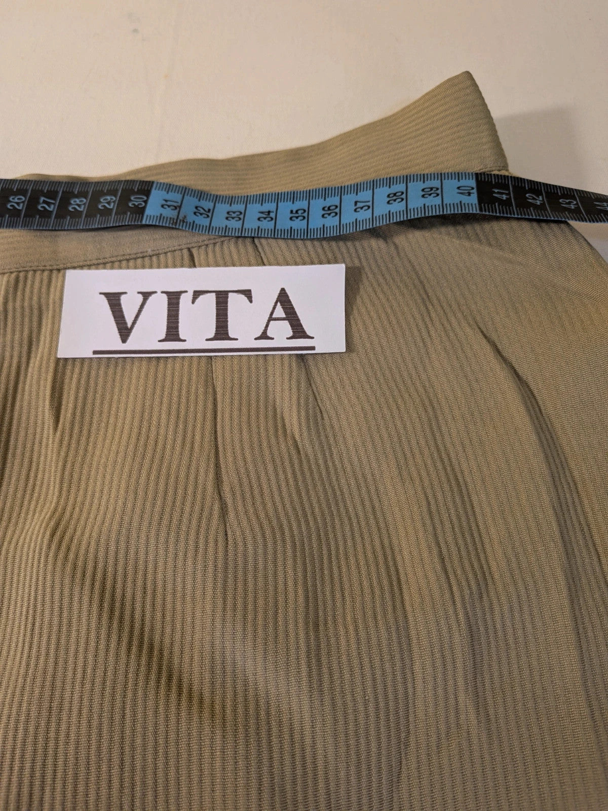 Krizia beige skirt suit with structured jacket, gold buttons, and pleated silk fabric.
