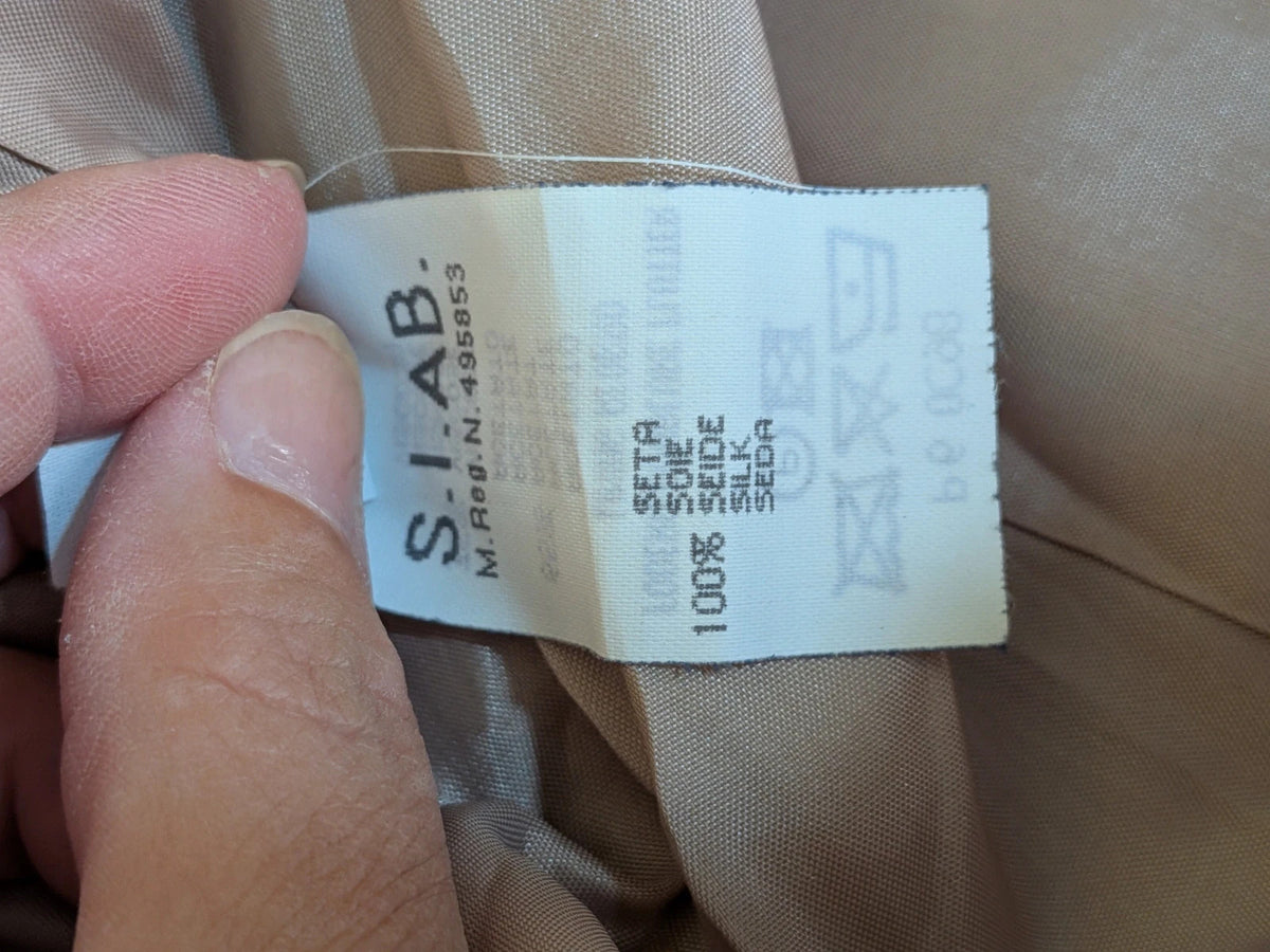 Krizia beige skirt suit with structured jacket, gold buttons, and pleated silk fabric.