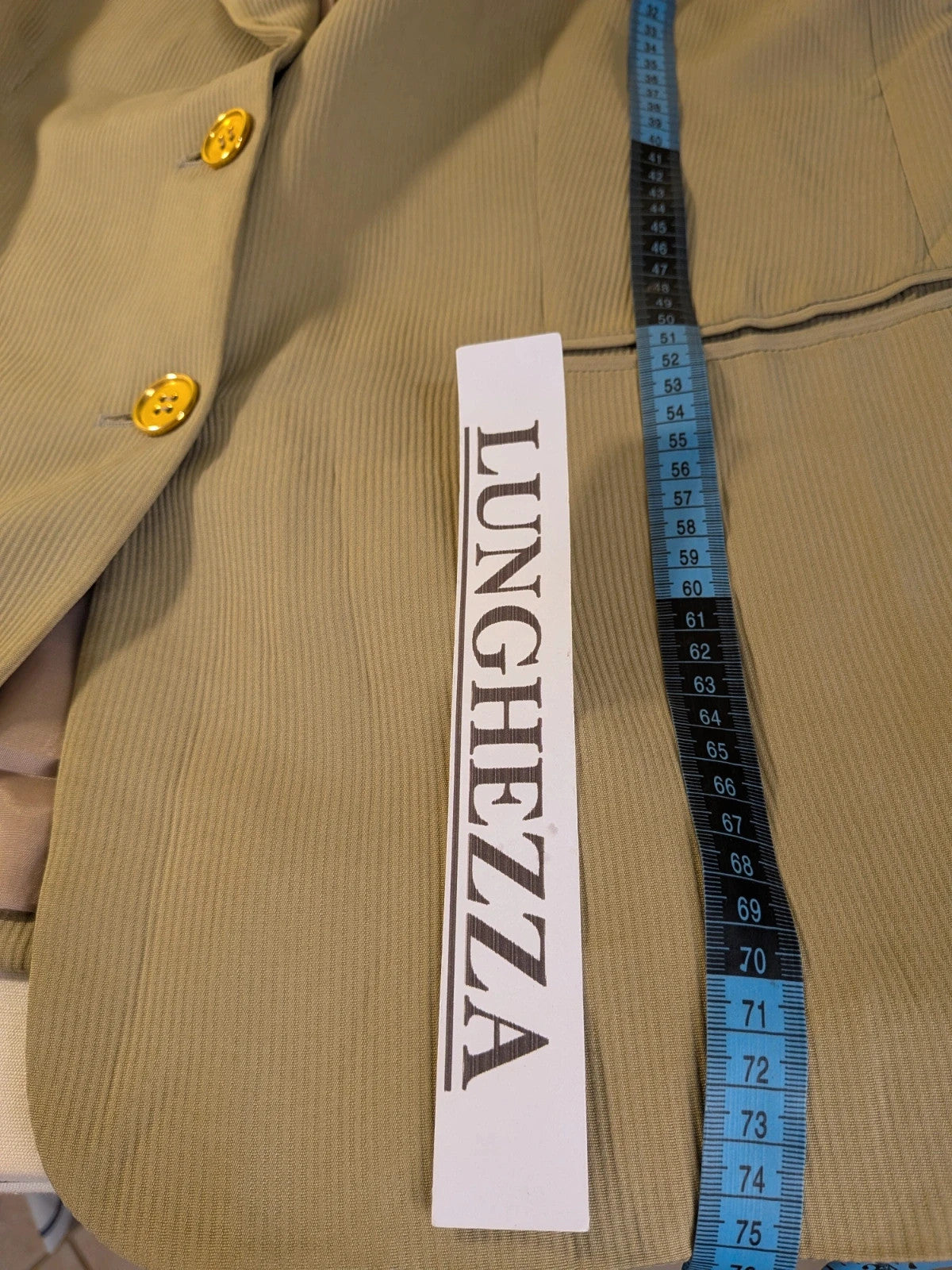 Krizia beige skirt suit with structured jacket, gold buttons, and pleated silk fabric.