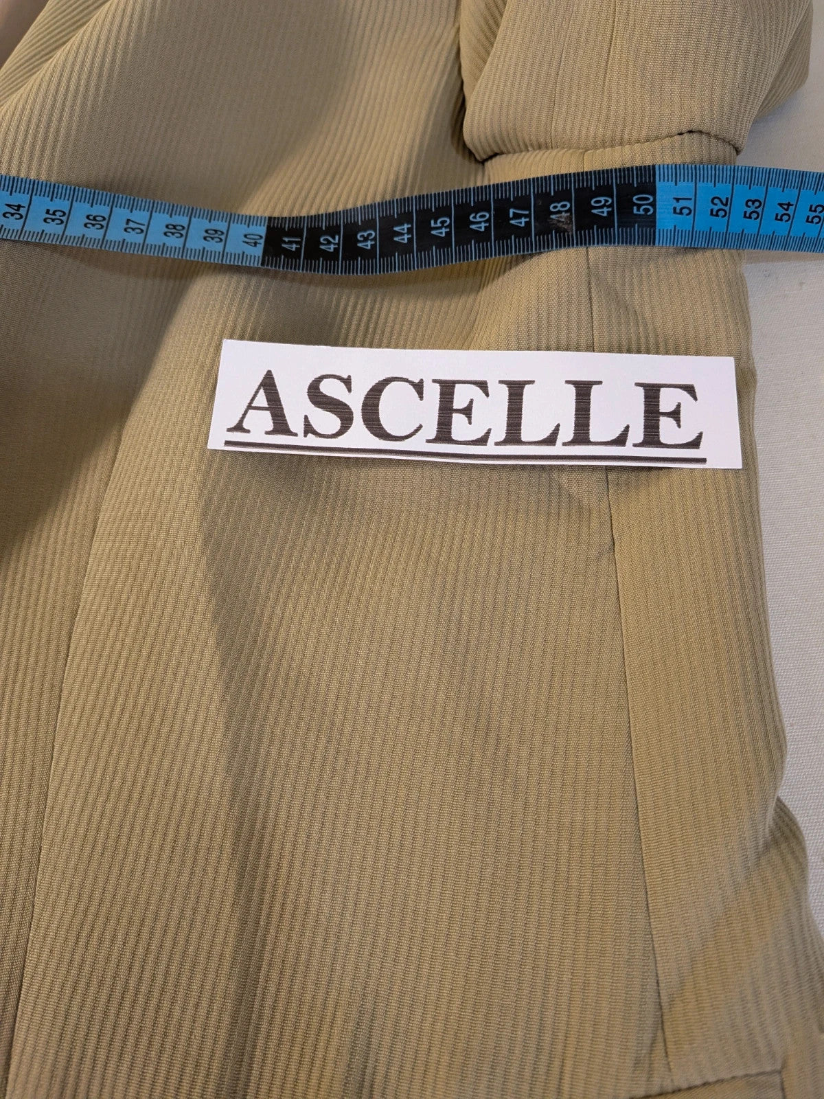 Krizia beige skirt suit with structured jacket, gold buttons, and pleated silk fabric.