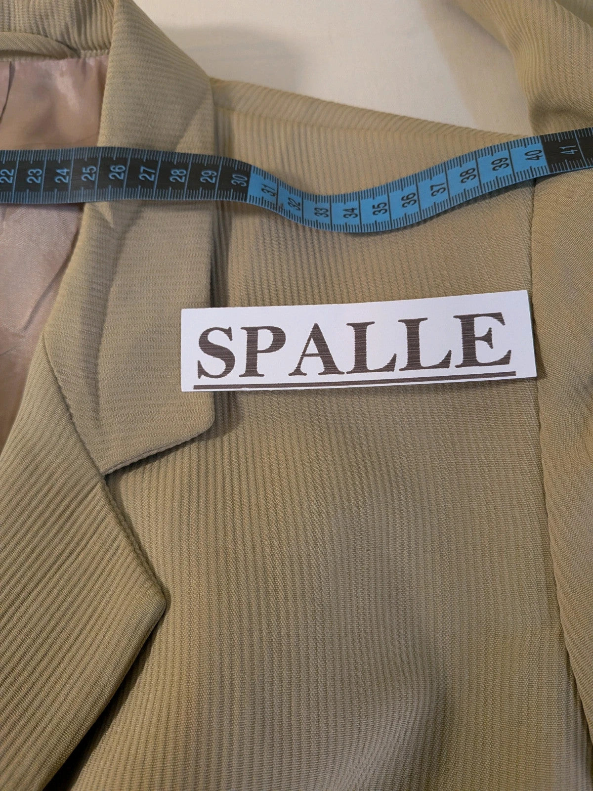 Krizia beige skirt suit with structured jacket, gold buttons, and pleated silk fabric.
