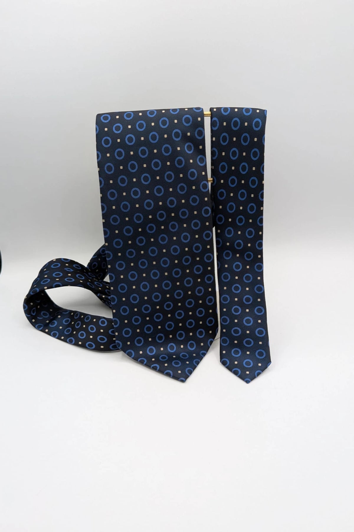 Milano navy tie geometric pattern with light blue rings and beige motifs, 100% silk.