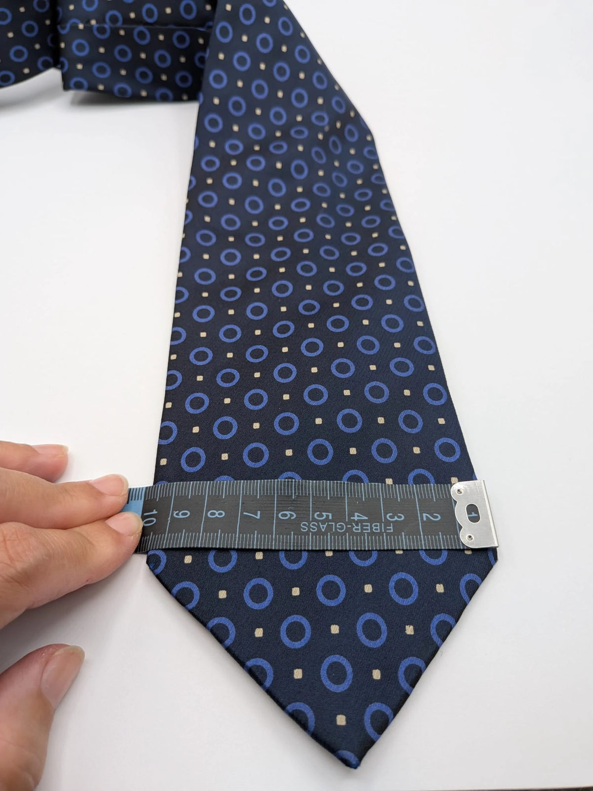 Milano navy tie geometric pattern with light blue rings and beige motifs, 100% silk.
