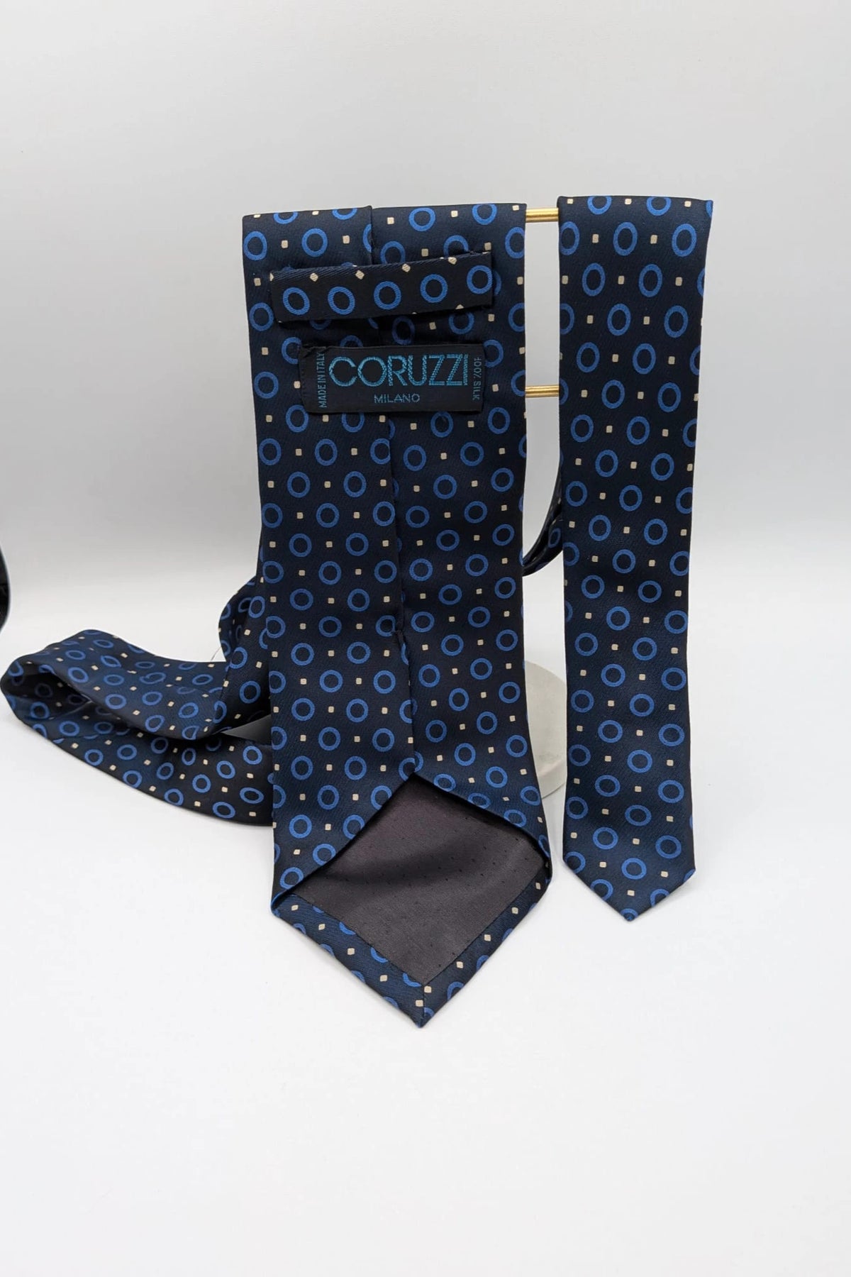 Milano navy tie geometric pattern with light blue rings and beige motifs, 100% silk.