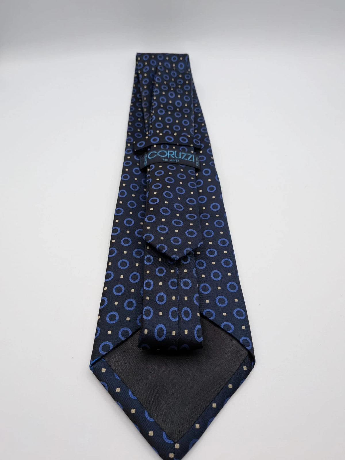 Milano navy tie geometric pattern with light blue rings and beige motifs, 100% silk.