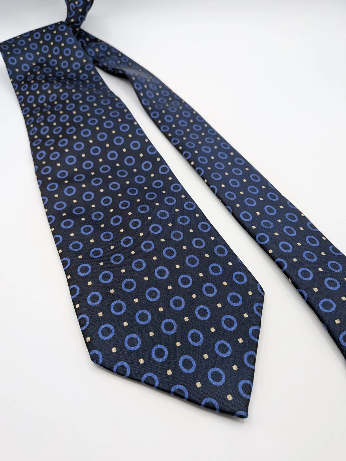 Milano navy tie geometric pattern with light blue rings and beige motifs, 100% silk.