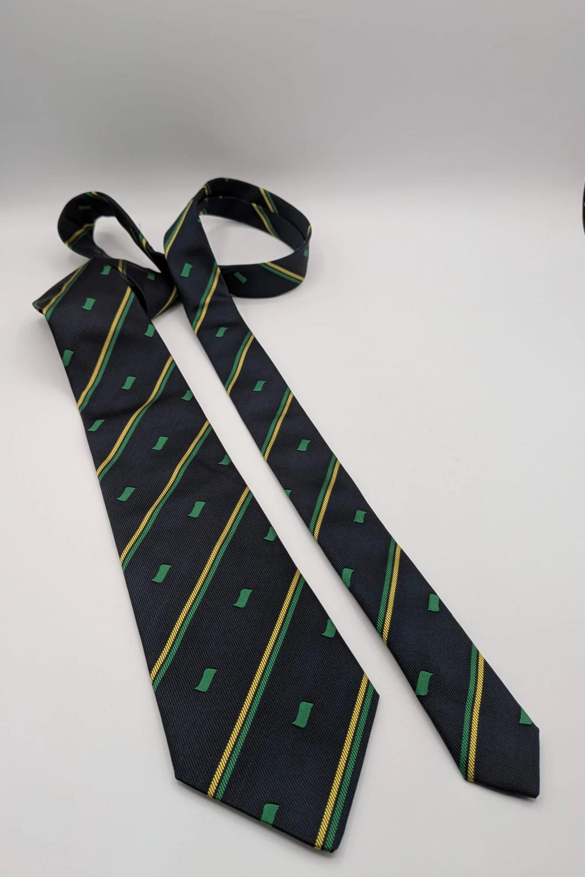 Norda tie navy blue with green and yellow diagonal stripes and geometric patterns.