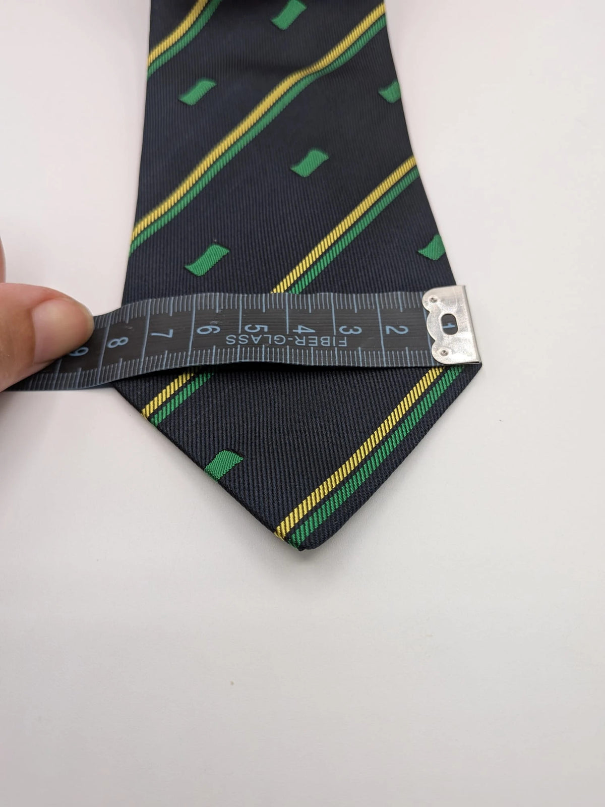 Norda tie navy blue with green and yellow diagonal stripes and geometric patterns.