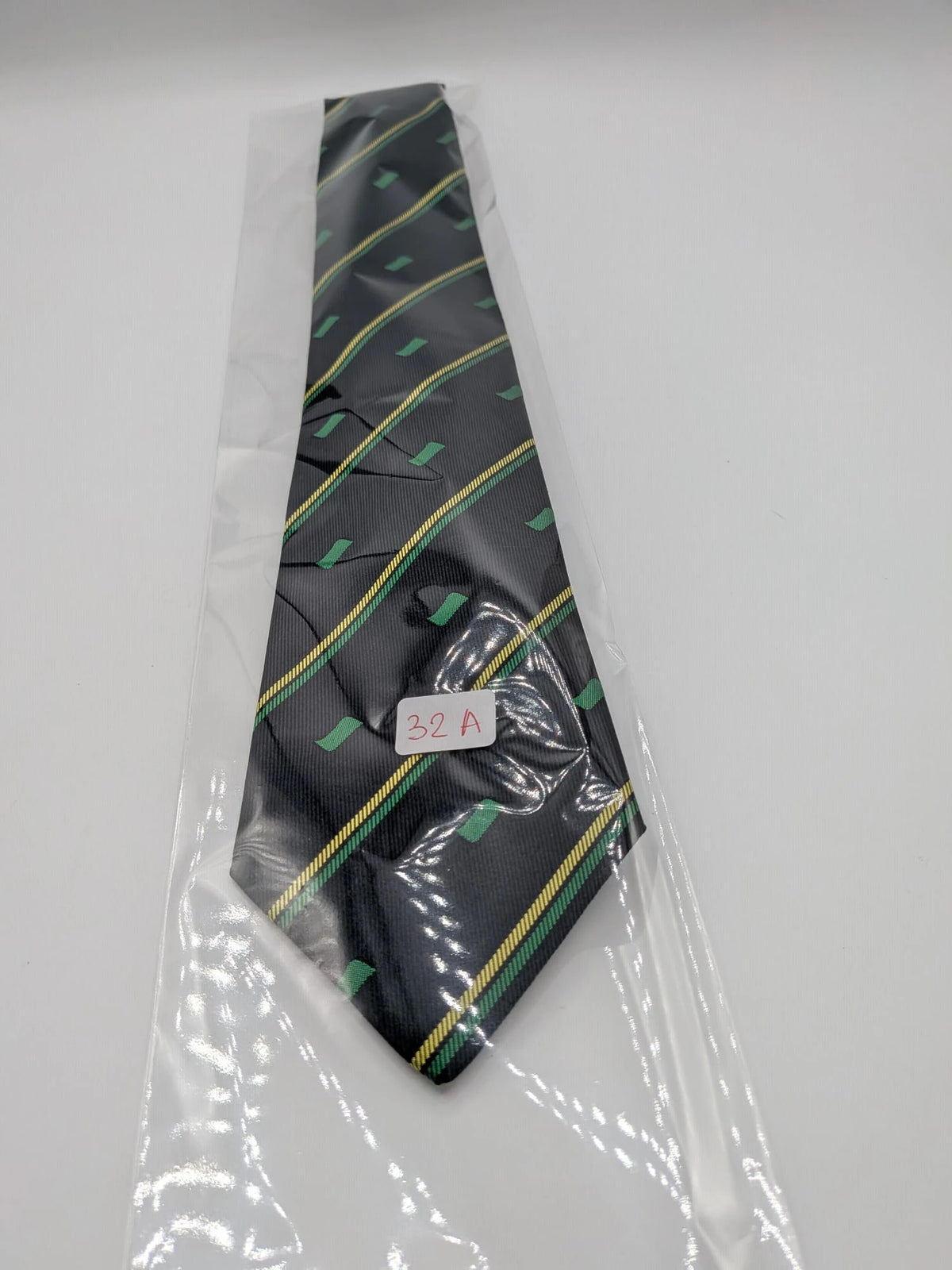 Norda tie navy blue with green and yellow diagonal stripes and geometric patterns.