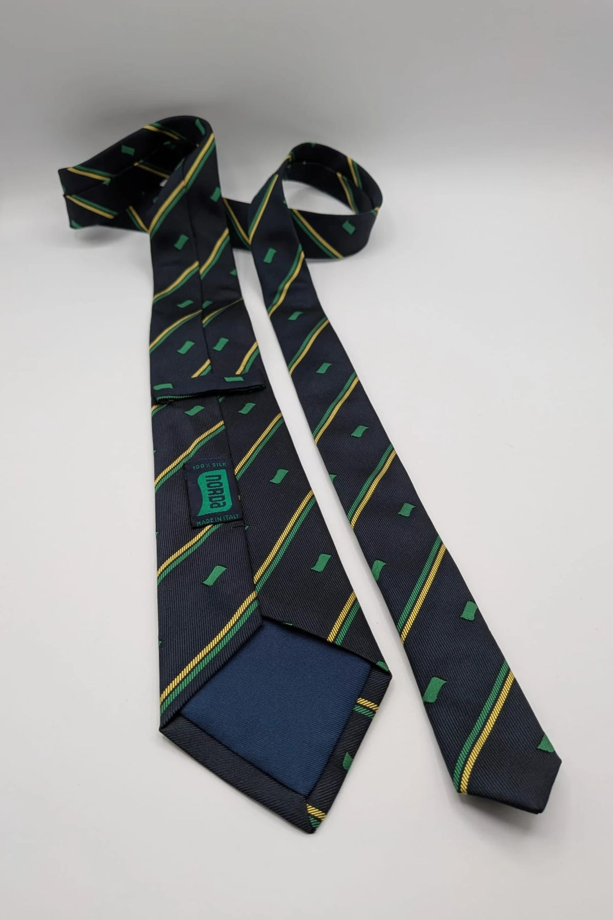 Norda tie navy blue with green and yellow diagonal stripes and geometric patterns.