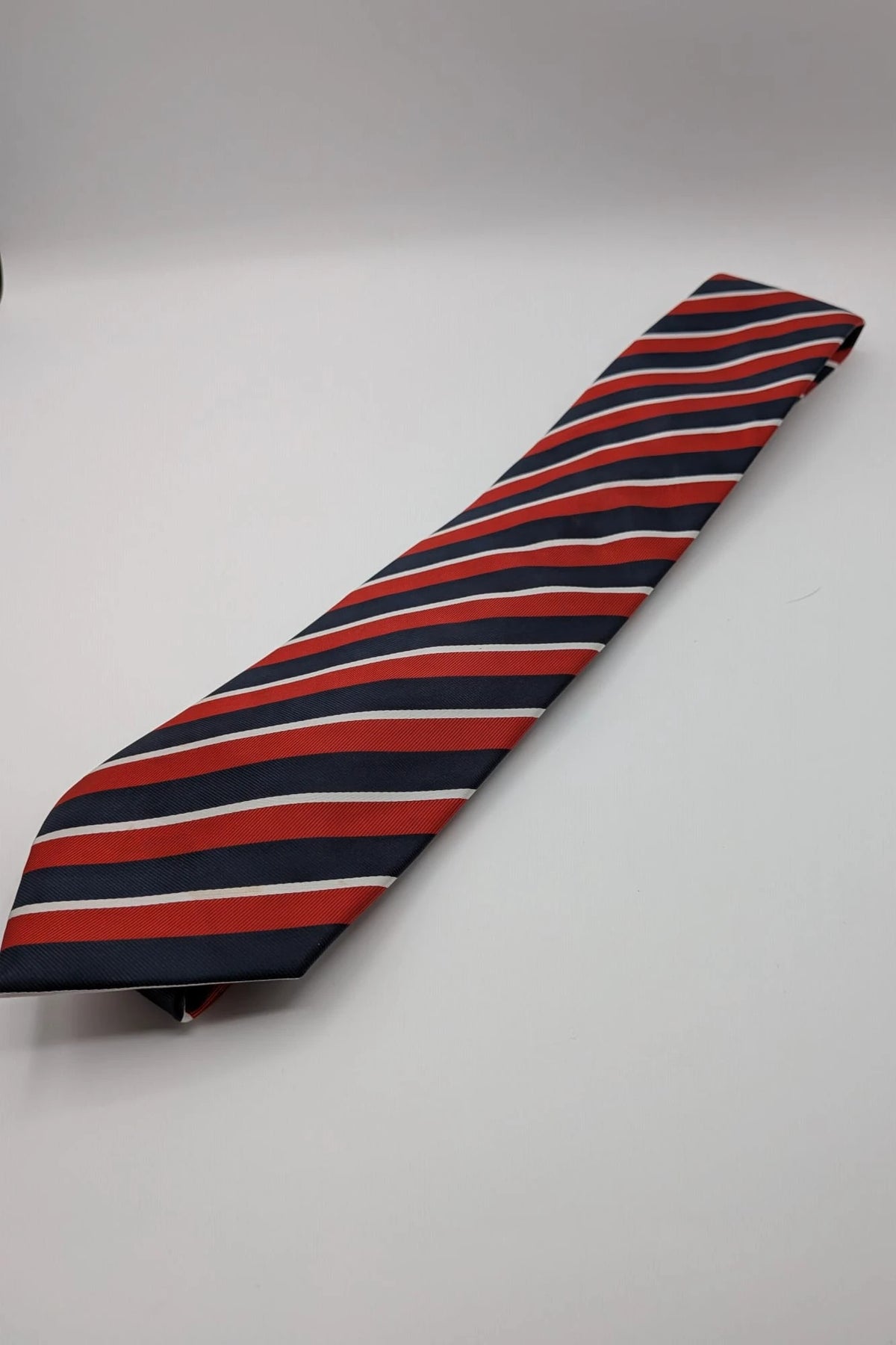 Uomo navy red diagonal striped silk tie with elegant pattern and Made in Italy label.