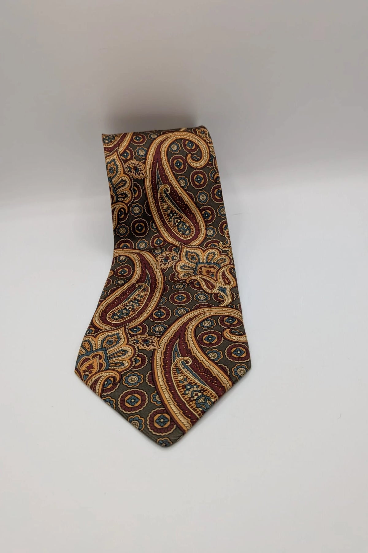 Uomo brown paisley tie in crèpe de chine with gold, blue, and burgundy patterns.