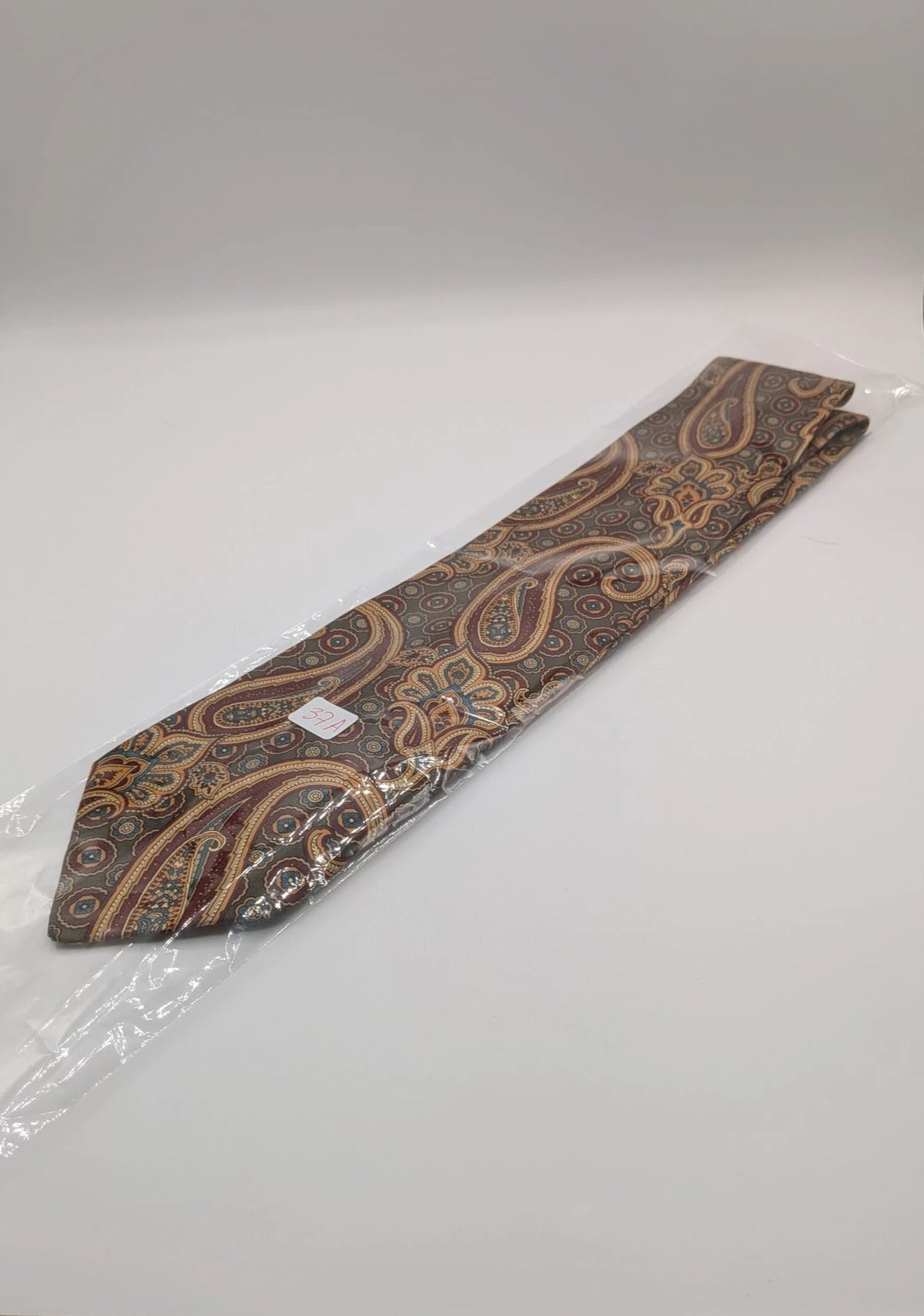 Uomo brown paisley tie in crèpe de chine with gold, blue, and burgundy patterns.