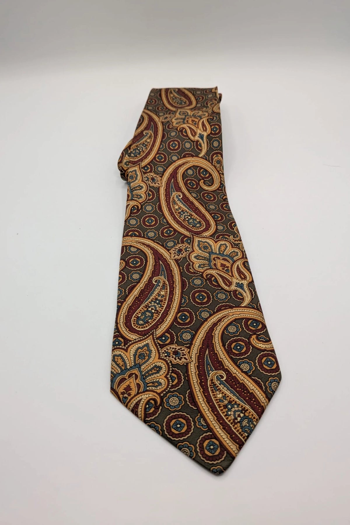 Uomo brown paisley tie in crèpe de chine with gold, blue, and burgundy patterns.