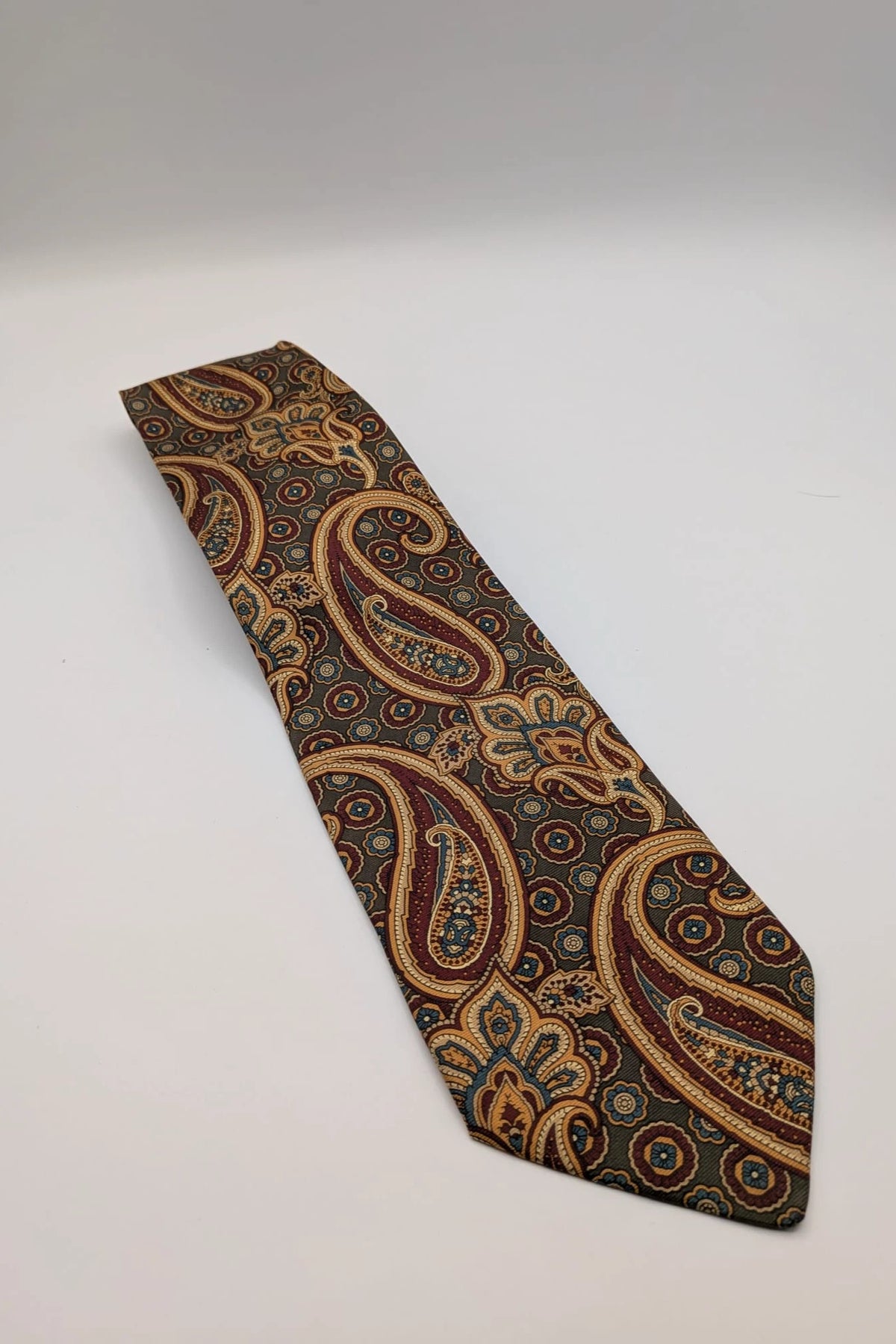 Uomo brown paisley tie in crèpe de chine with gold, blue, and burgundy patterns.