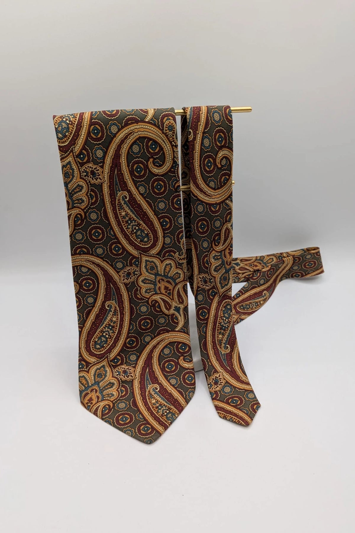 Uomo brown paisley tie in crèpe de chine with gold, blue, and burgundy patterns.