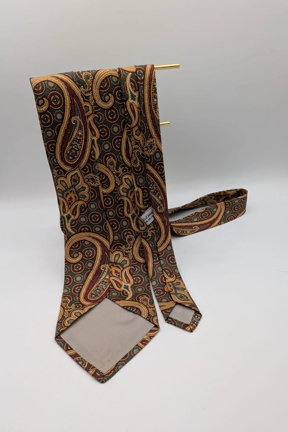 Uomo brown paisley tie in crèpe de chine with gold, blue, and burgundy patterns.