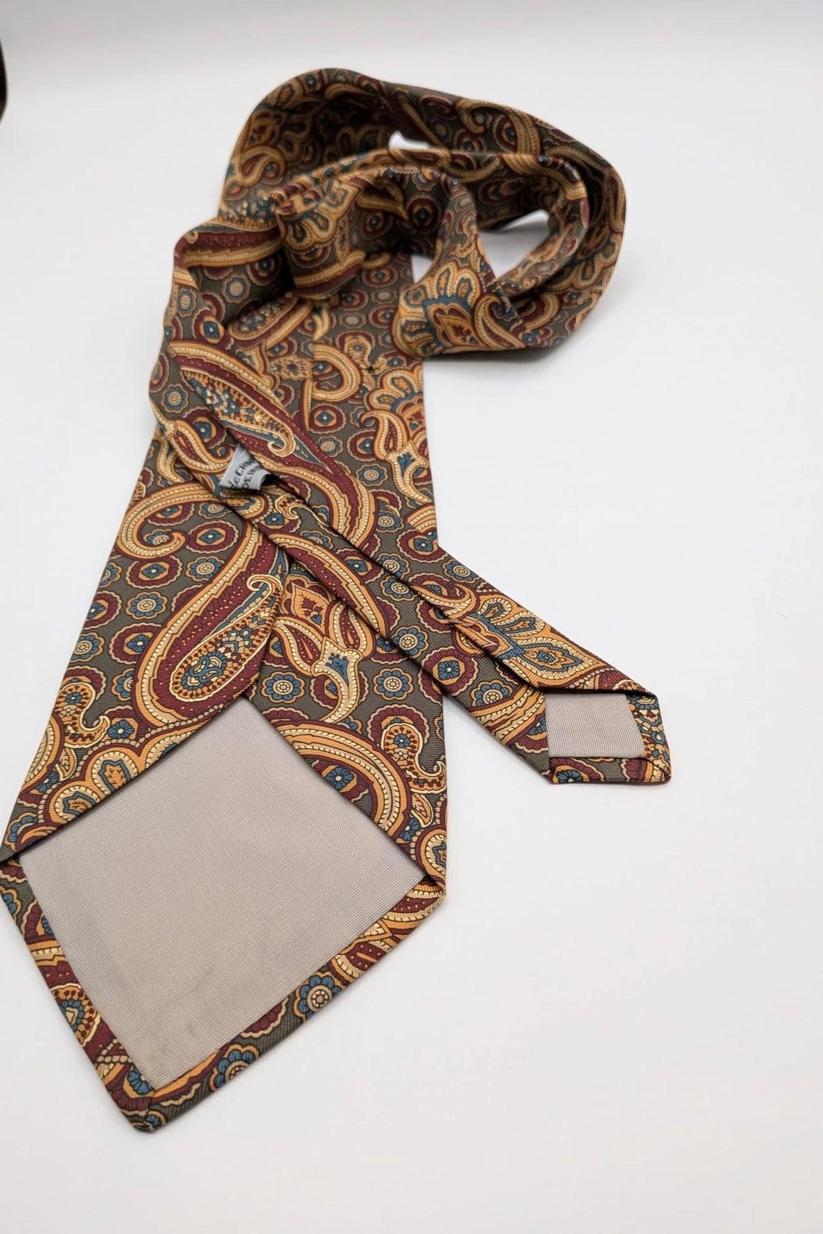 Uomo brown paisley tie in crèpe de chine with gold, blue, and burgundy patterns.