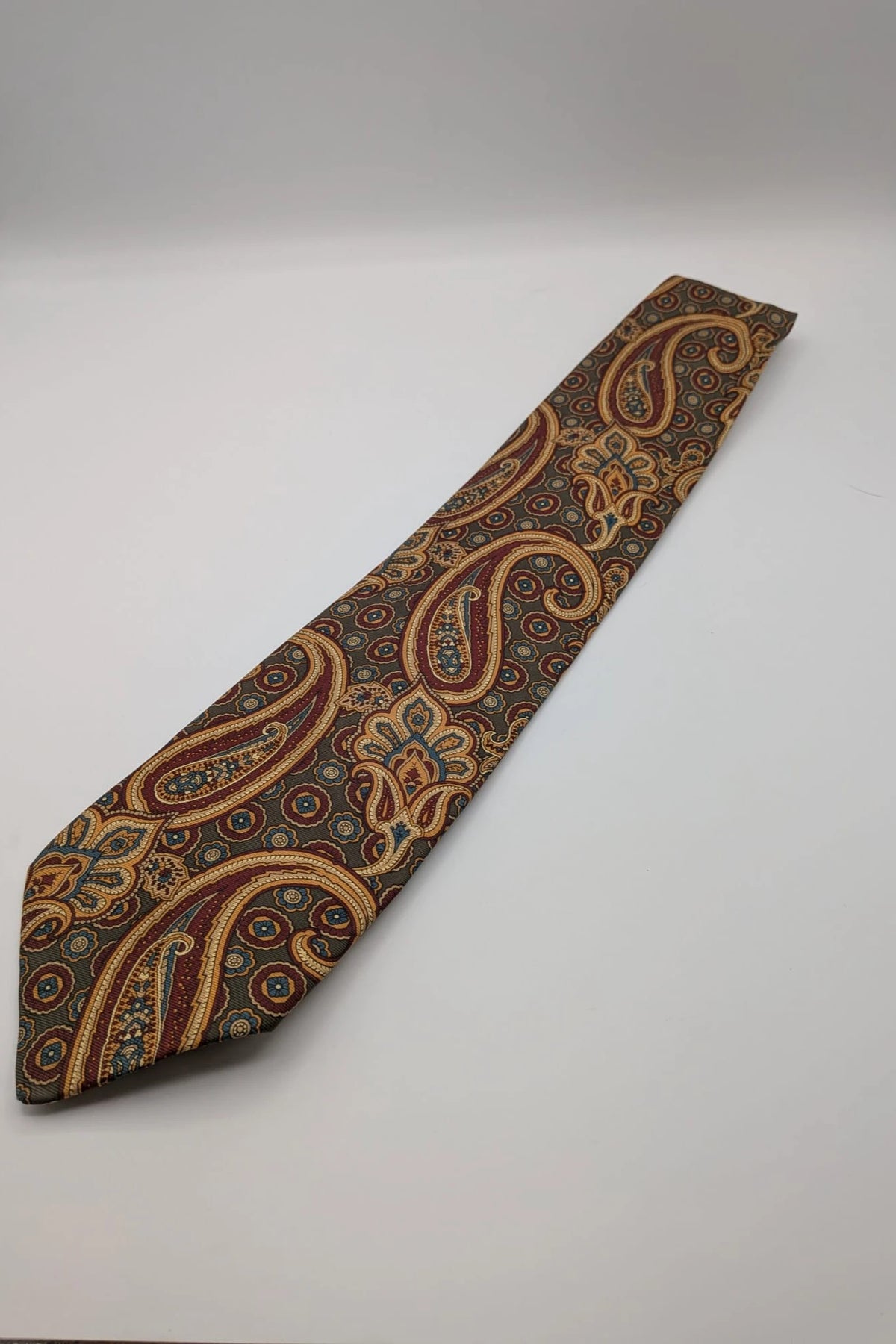 Uomo brown paisley tie in crèpe de chine with gold, blue, and burgundy patterns.