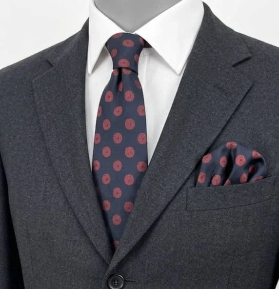 Uomo navy blue tie with red polka dots and diagonal stripes detail.