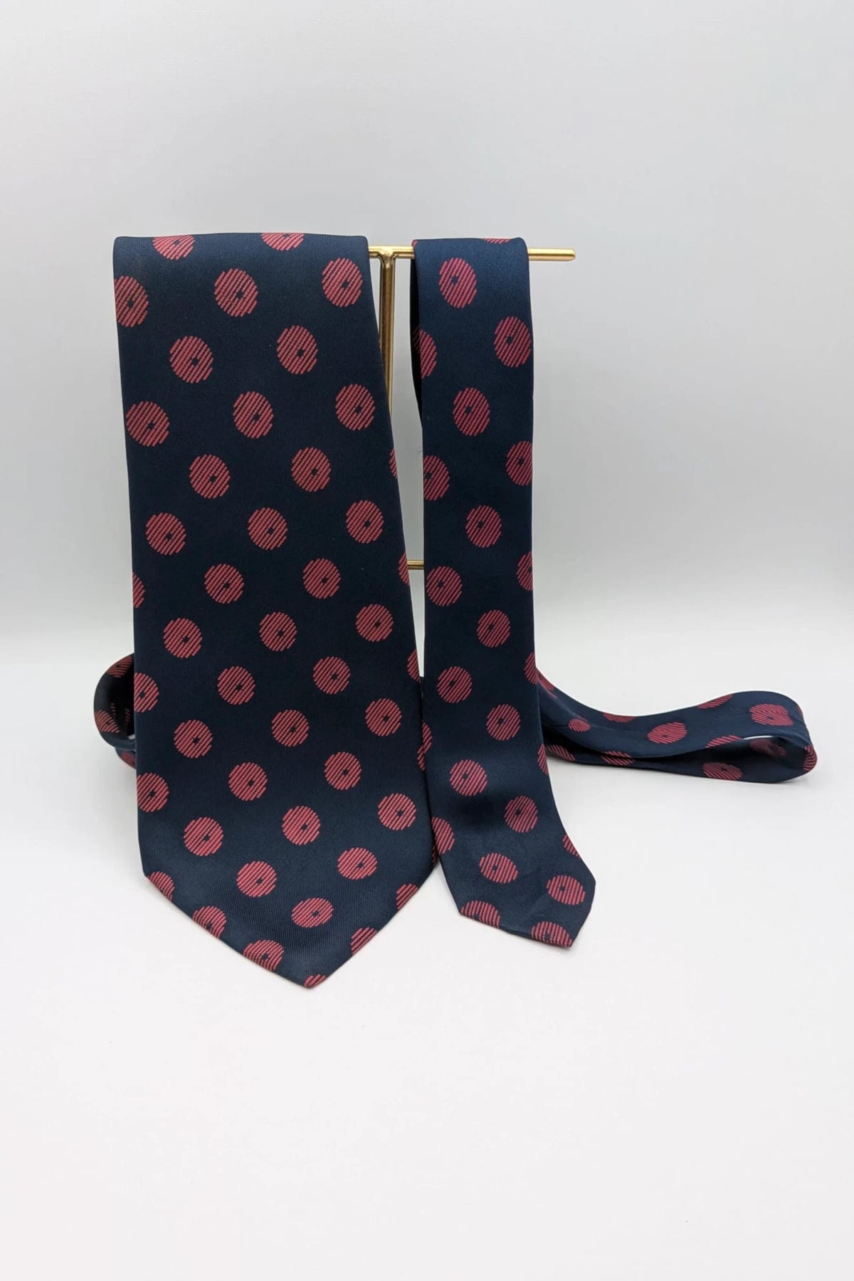 Uomo navy blue tie with red polka dots and diagonal stripes detail.