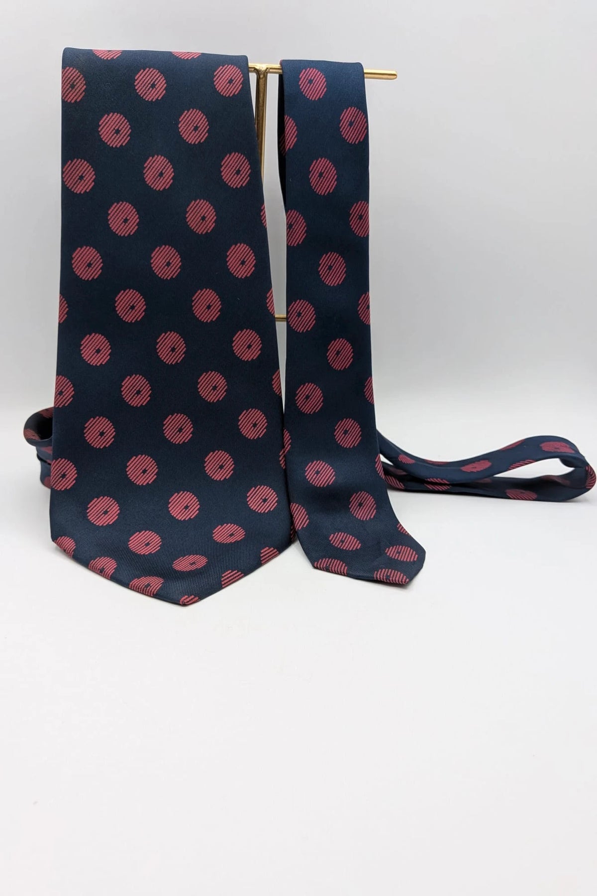 Uomo navy blue tie with red polka dots and diagonal stripes detail.