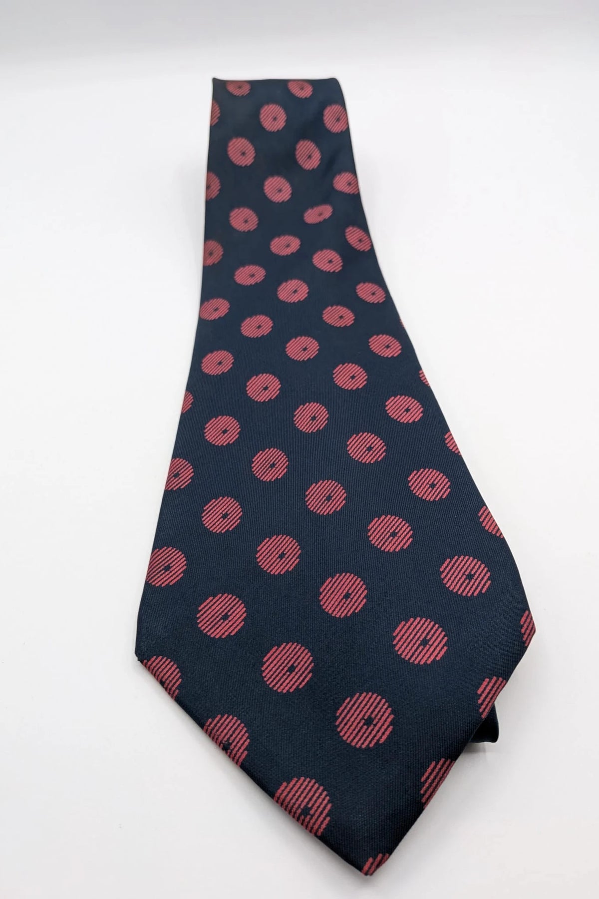Uomo navy blue tie with red polka dots and diagonal stripes detail.