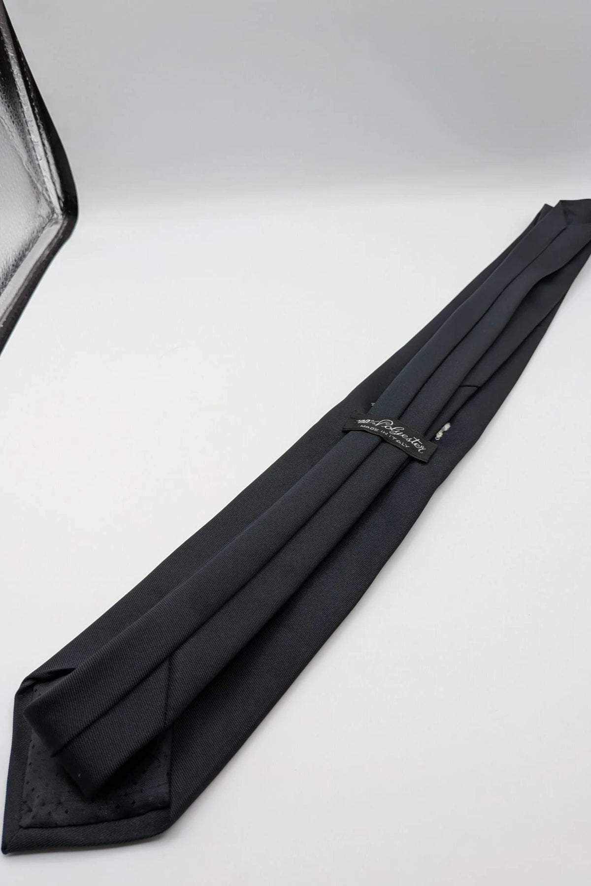 Uomo black tie with embroidered white logo, 100% polyester, Made in Italy.