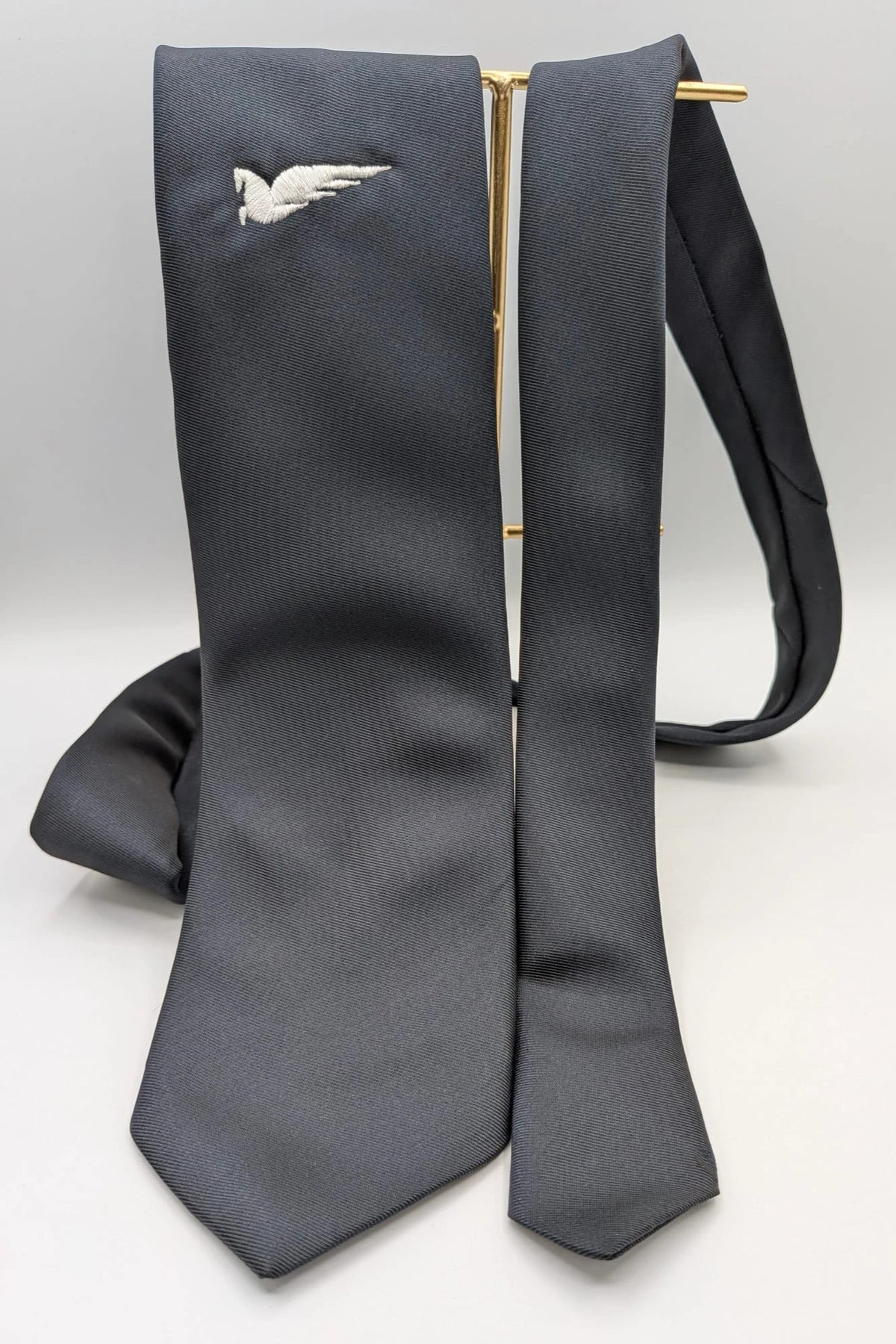 Uomo black tie with embroidered white logo, 100% polyester, Made in Italy.