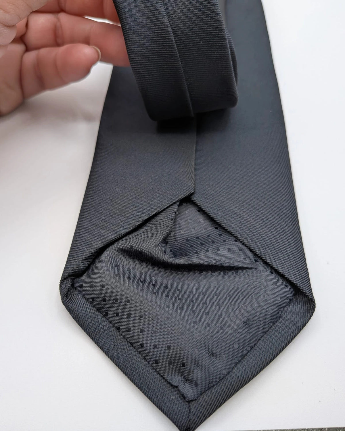 Uomo black tie with embroidered white logo, 100% polyester, Made in Italy.