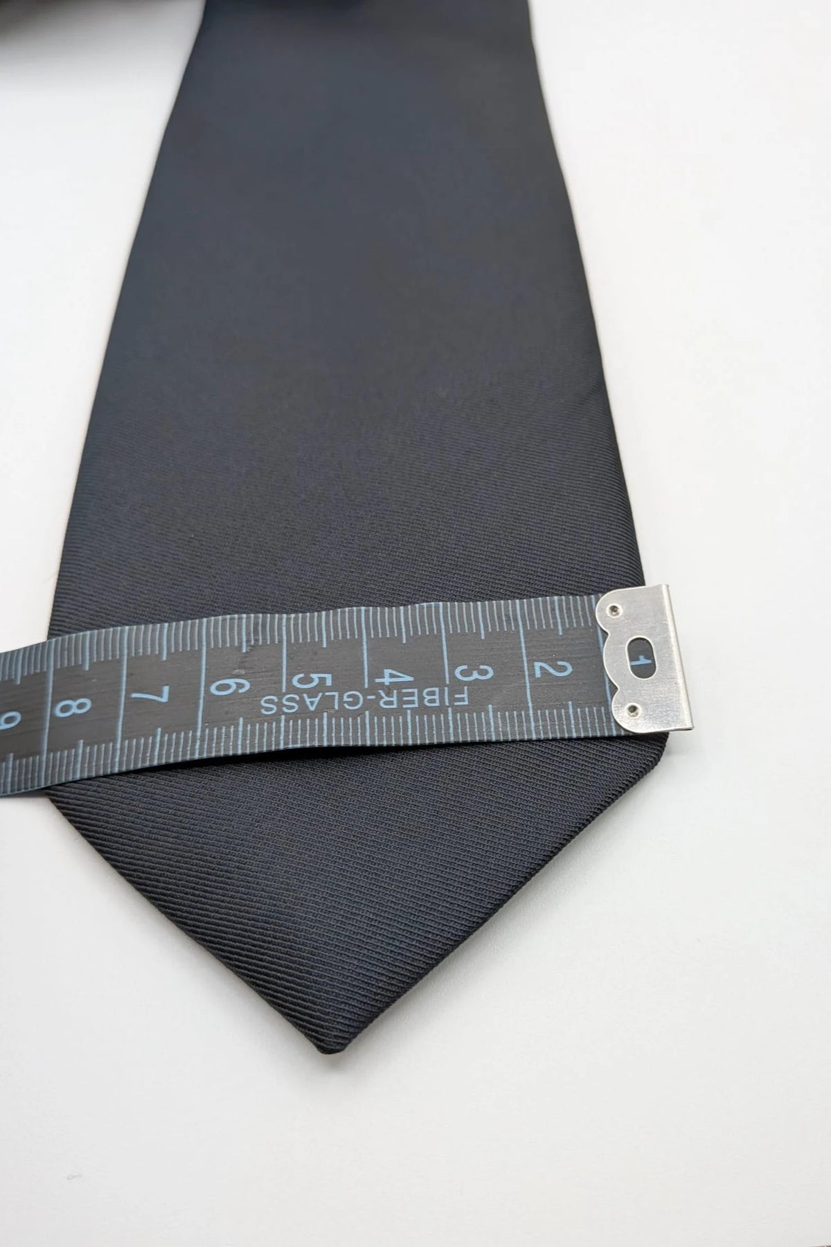 Uomo black tie with embroidered white logo, 100% polyester, Made in Italy.