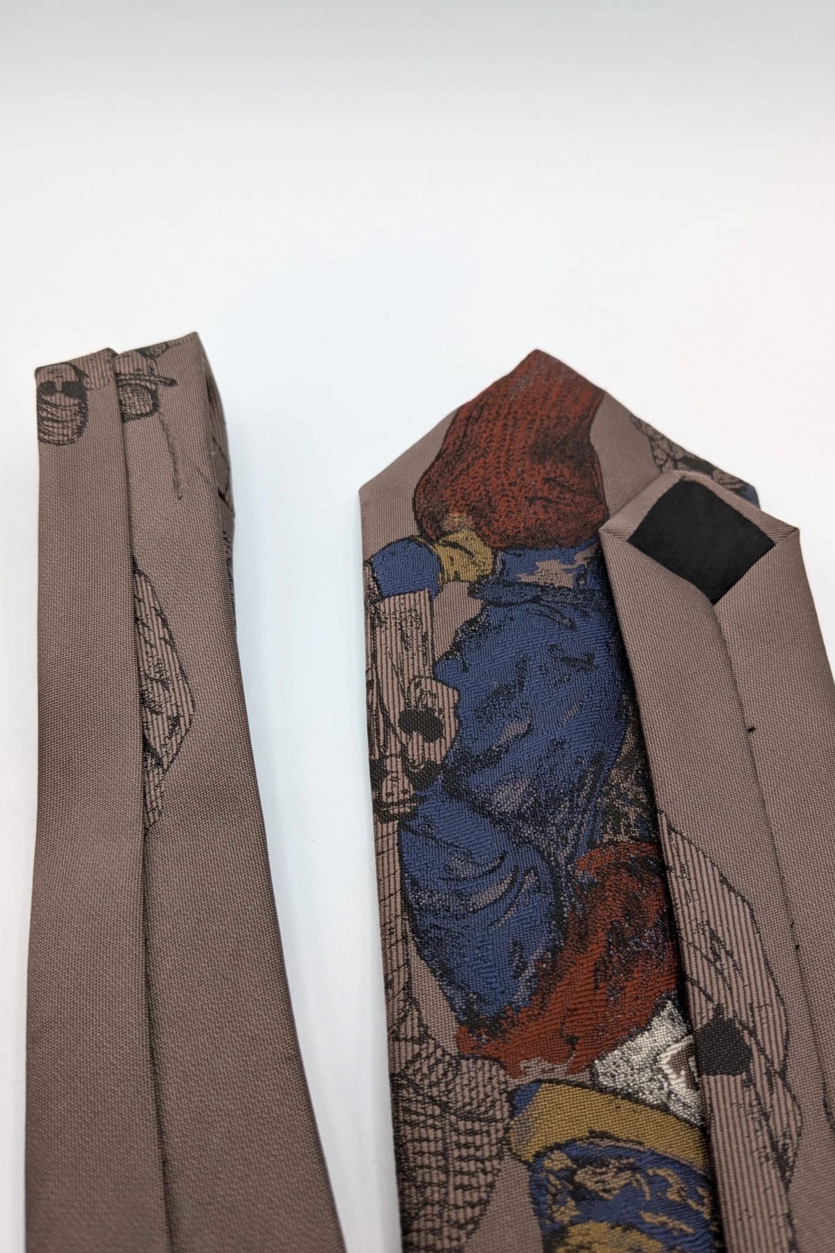 Uomo brown tie vintage illustrated pattern with blue, bordeaux, and ochre details.