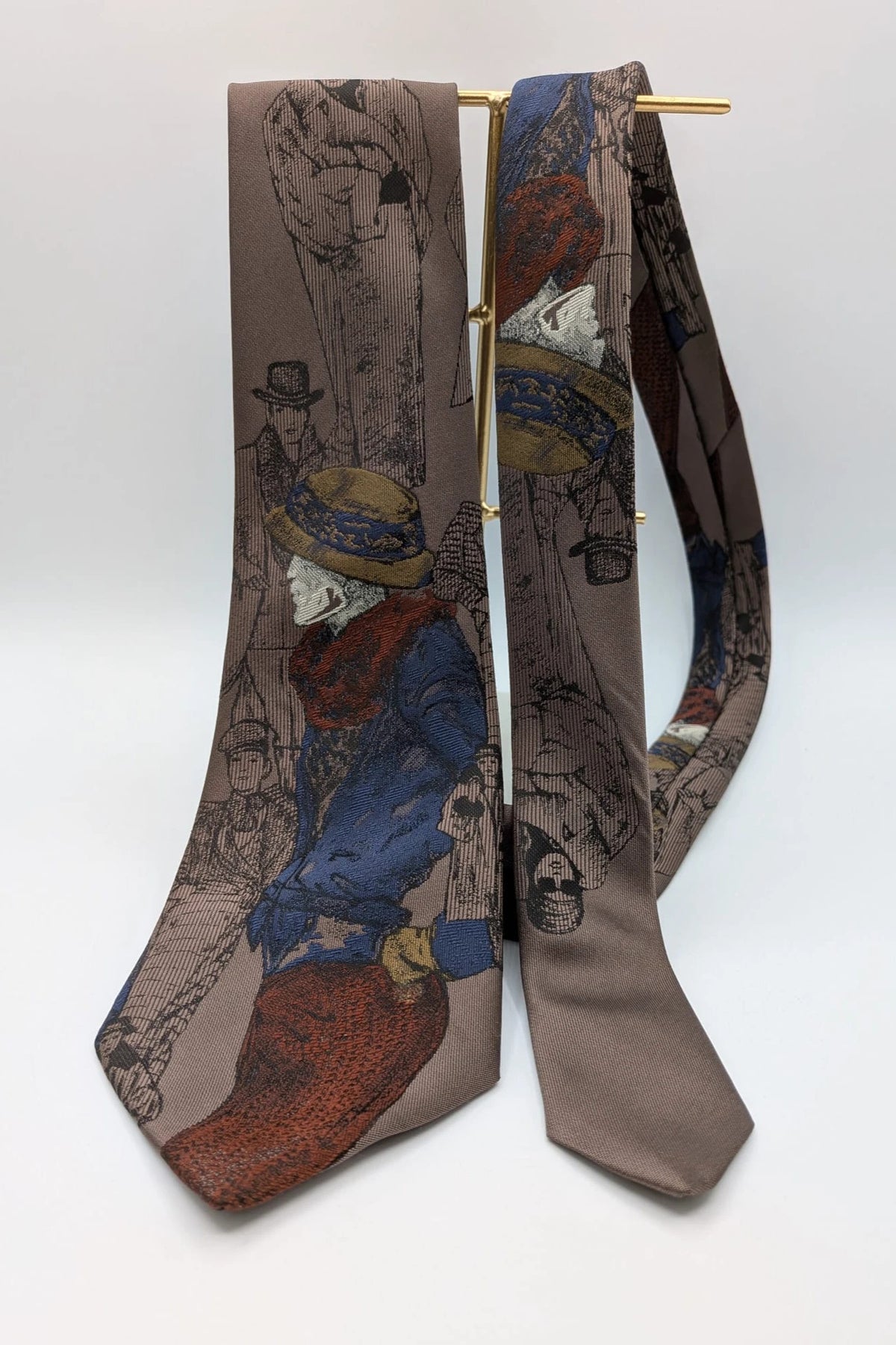 Uomo brown tie vintage illustrated pattern with blue, bordeaux, and ochre details.