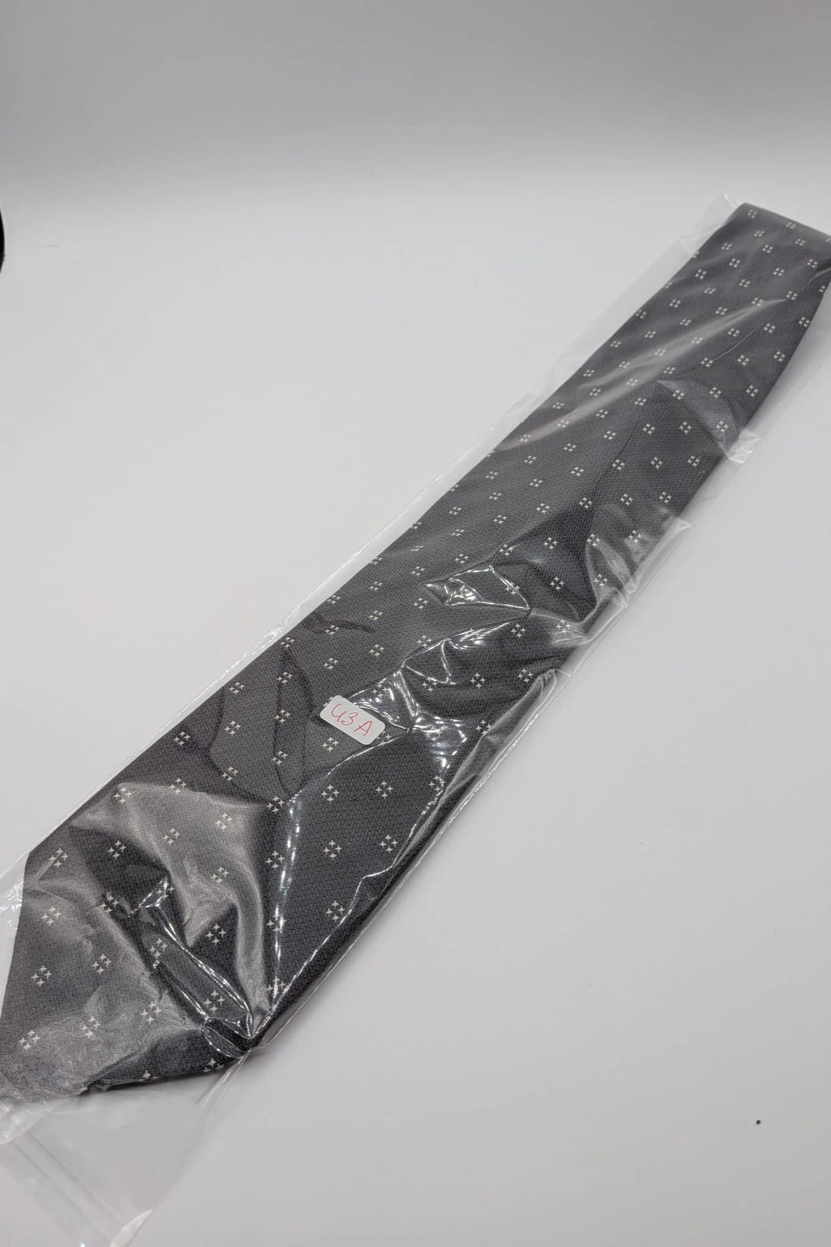 Prochownick grey silk tie with ivory geometric pattern and 8 cm wide blade.