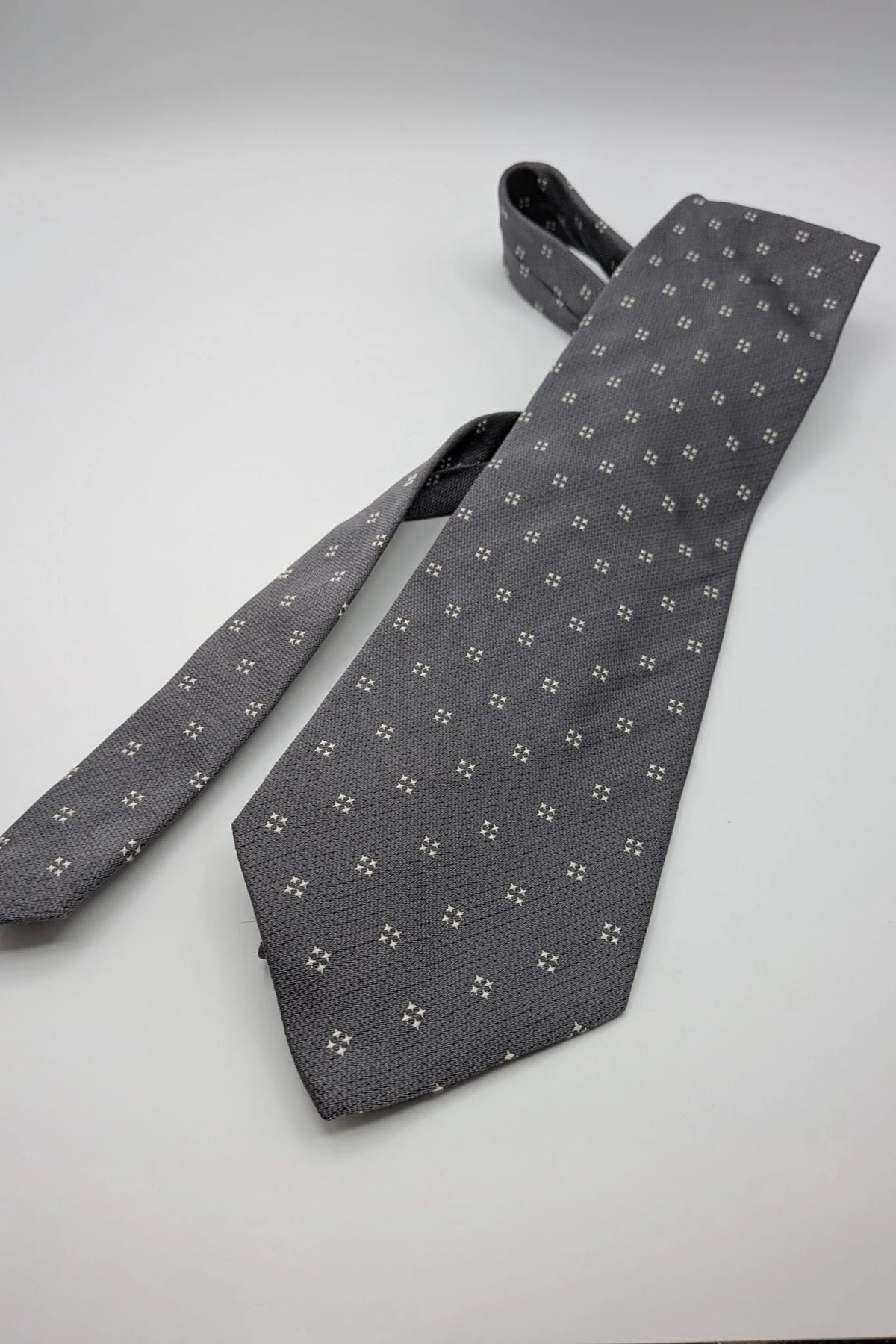 Prochownick grey silk tie with ivory geometric pattern and 8 cm wide blade.