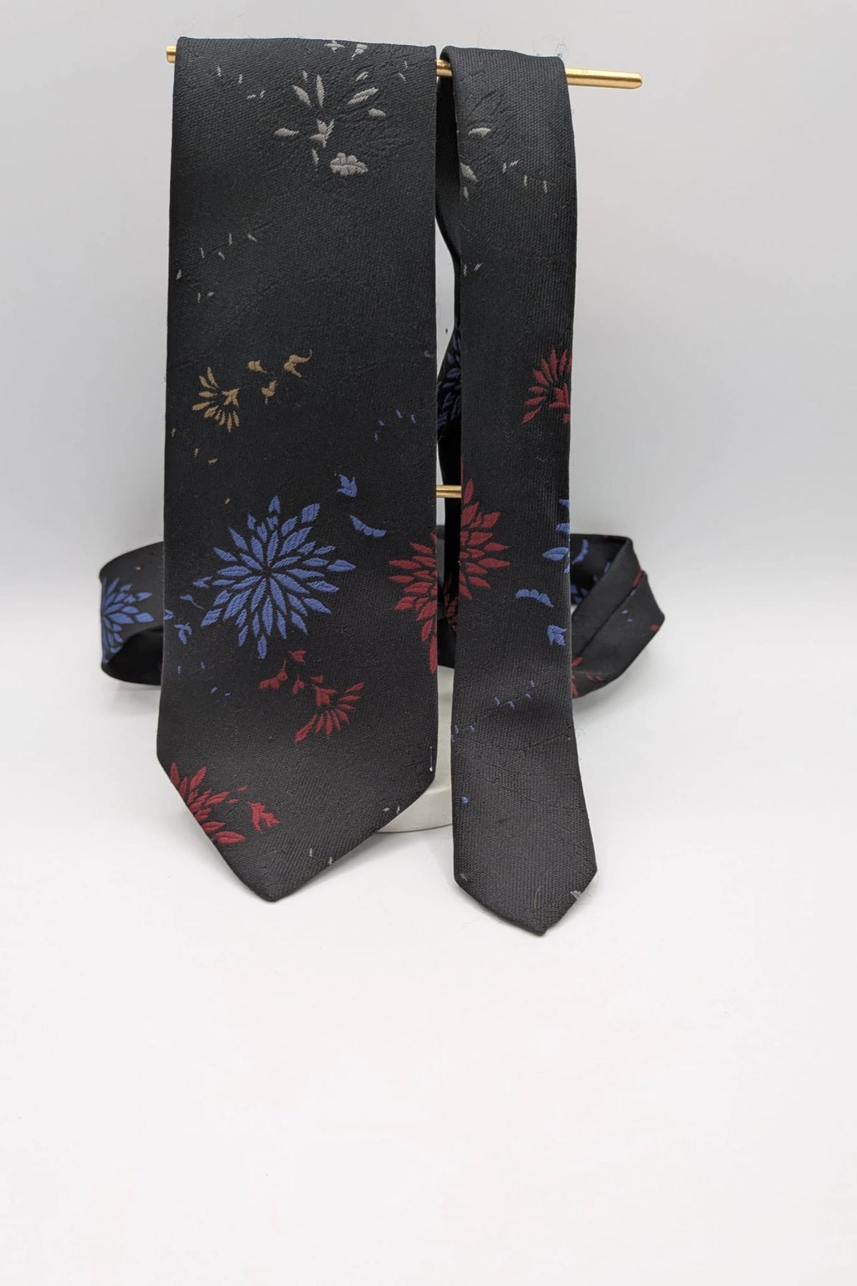 Uomo black tie with red and blue floral pattern, "Misto Seta" label, Made in Italy.