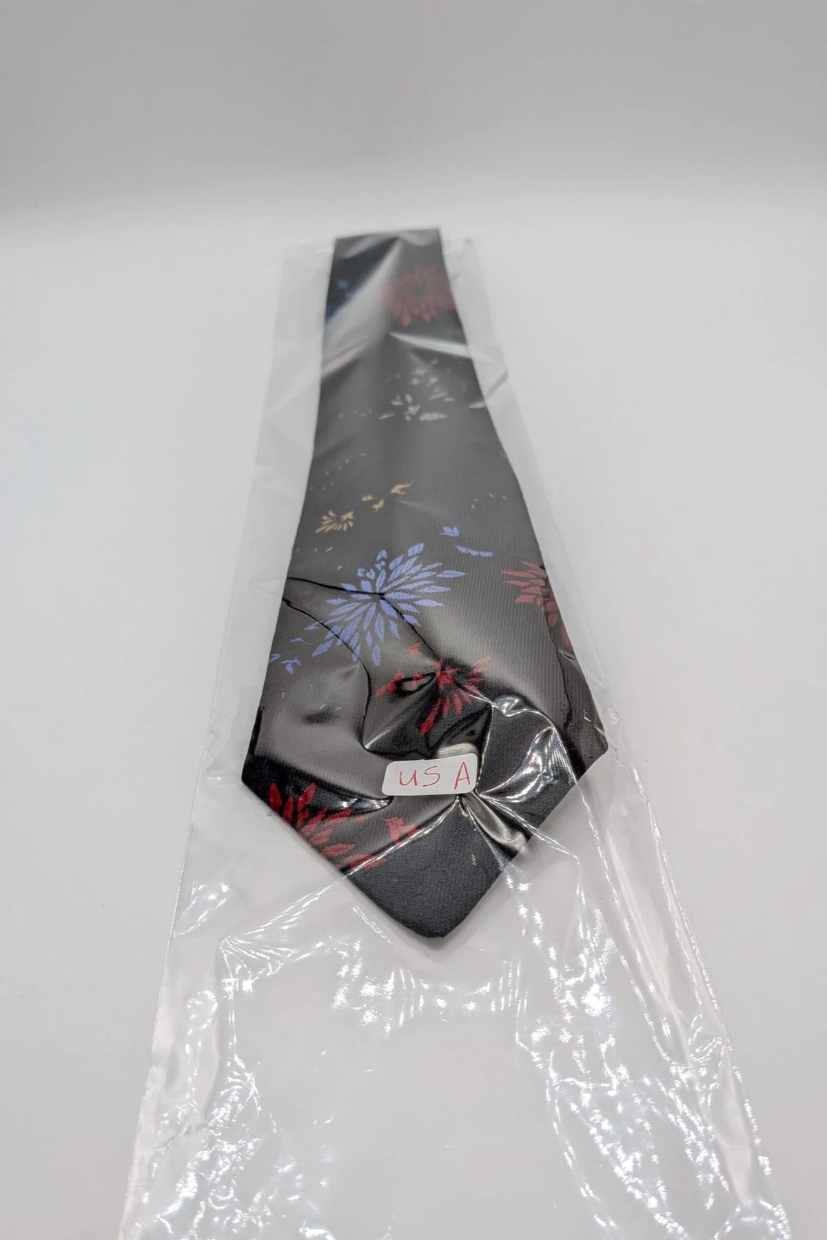 Uomo black tie with red and blue floral pattern, "Misto Seta" label, Made in Italy.