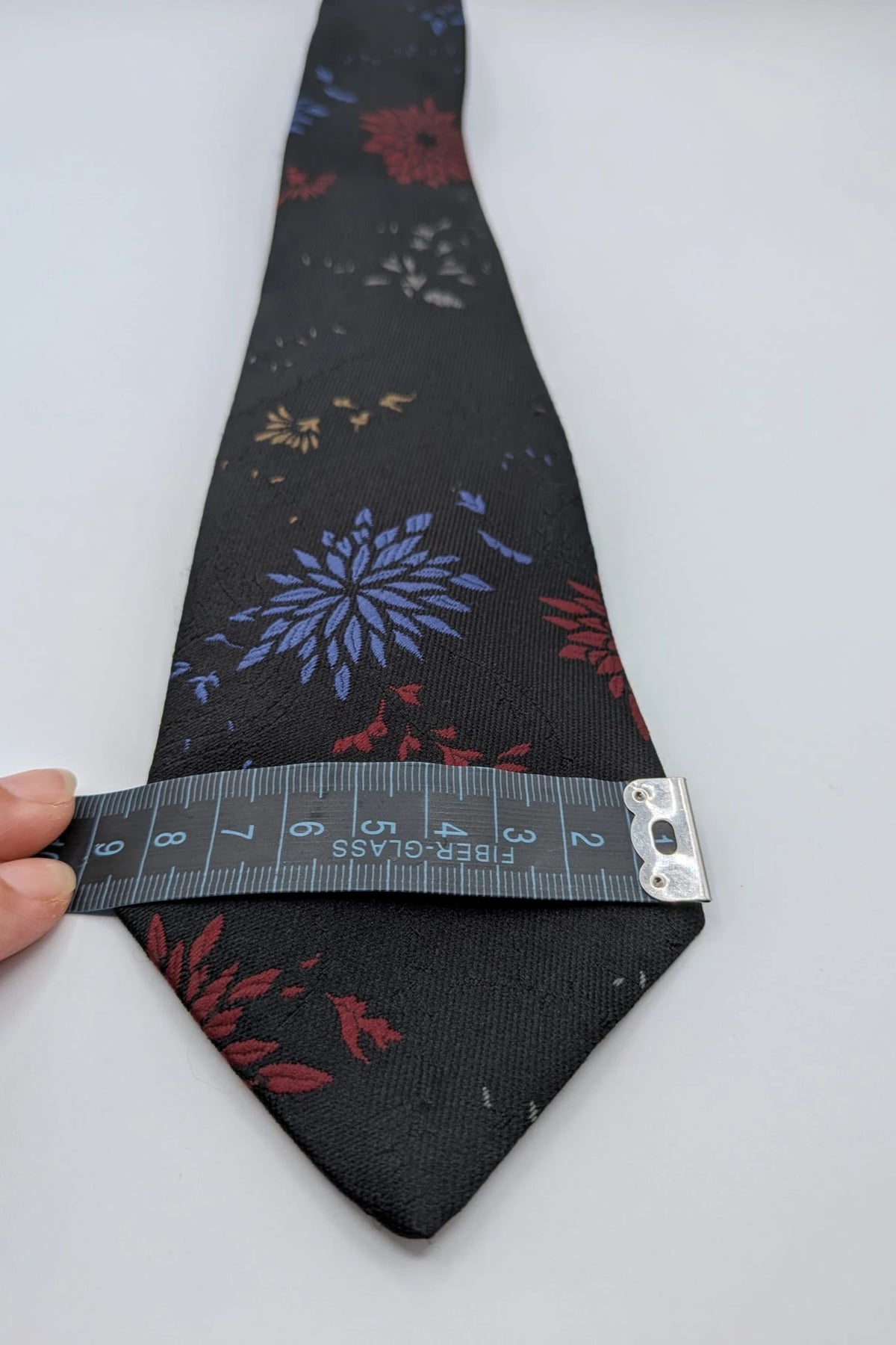 Uomo black tie with red and blue floral pattern, "Misto Seta" label, Made in Italy.